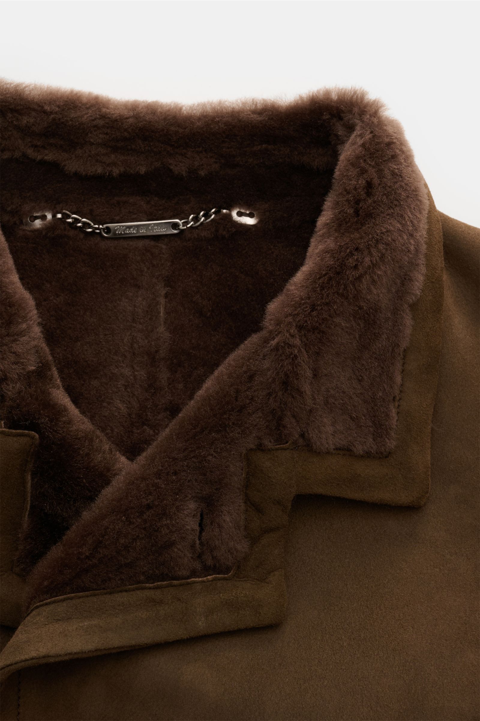 Nahaufnahme der Rifugio Lammfelljacke braun von oben, zeigt Reverskragen mit weichem, dunkelbraunem Lammfell und feinstem Lammveloursleder.