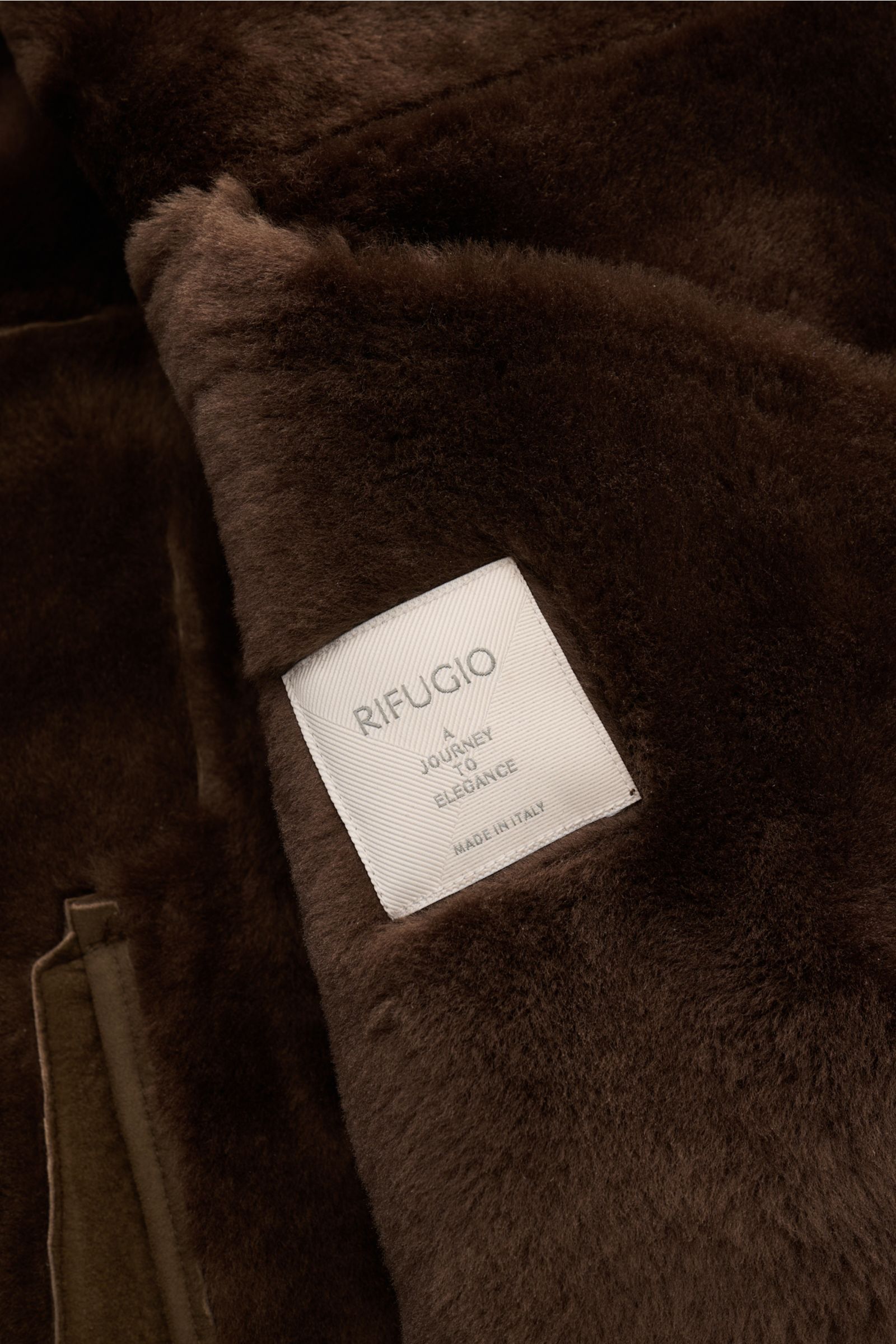 Nahaufnahme der Innenseite der Rifugio Lammfelljacke braun, feinstes Lammveloursleder, weicher Griff, sichtbares Futter und Label.