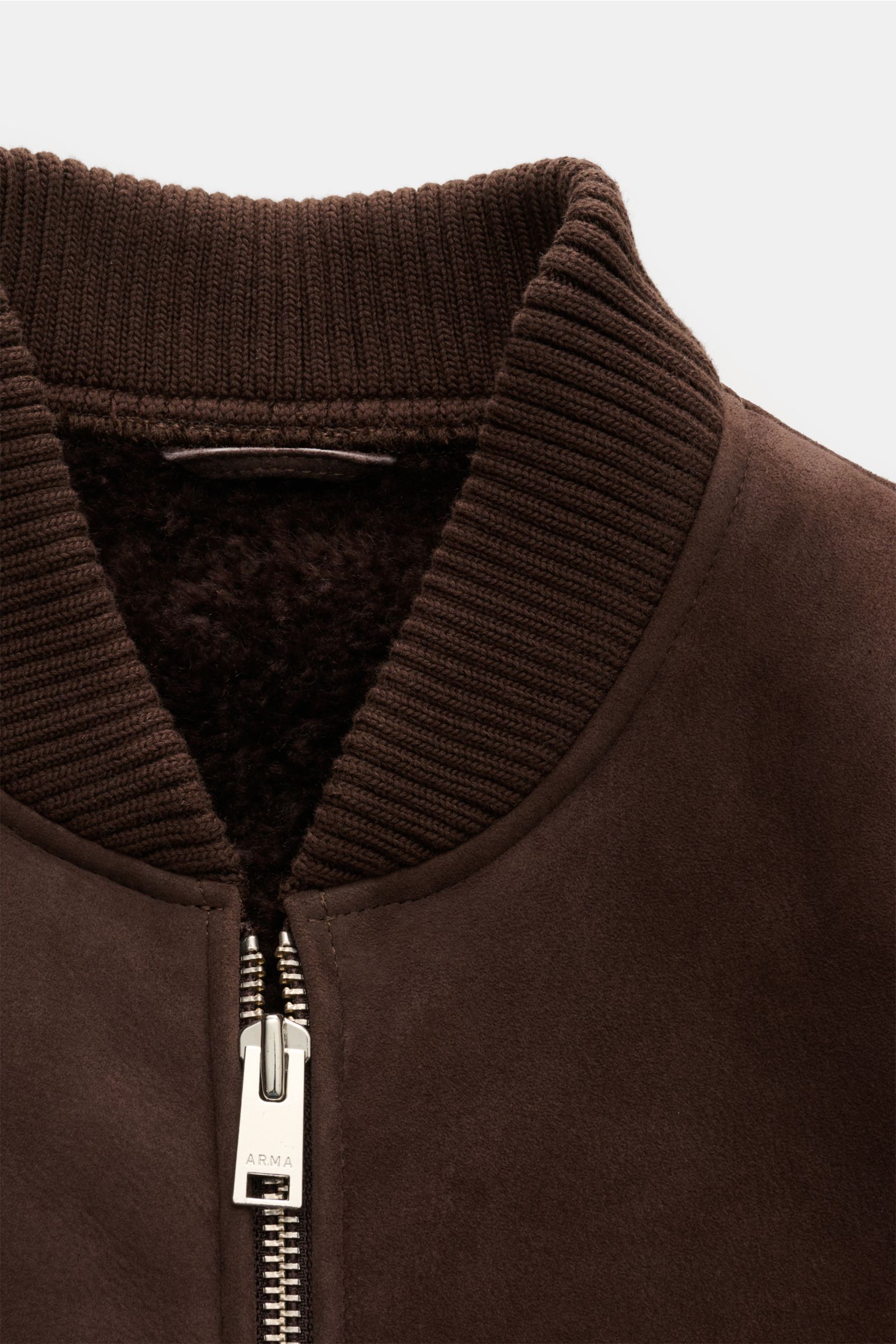 Close-up front view of the collar and zipper of the Arma Lammfellblouson 'Gillo' dunkelbraun, featuring soft lamb velour leather exterior, ribbed bomber collar, and plush lambswool interior for warmth. Der Lammfellblouson 'Gillo' von ARMA verbindet mas