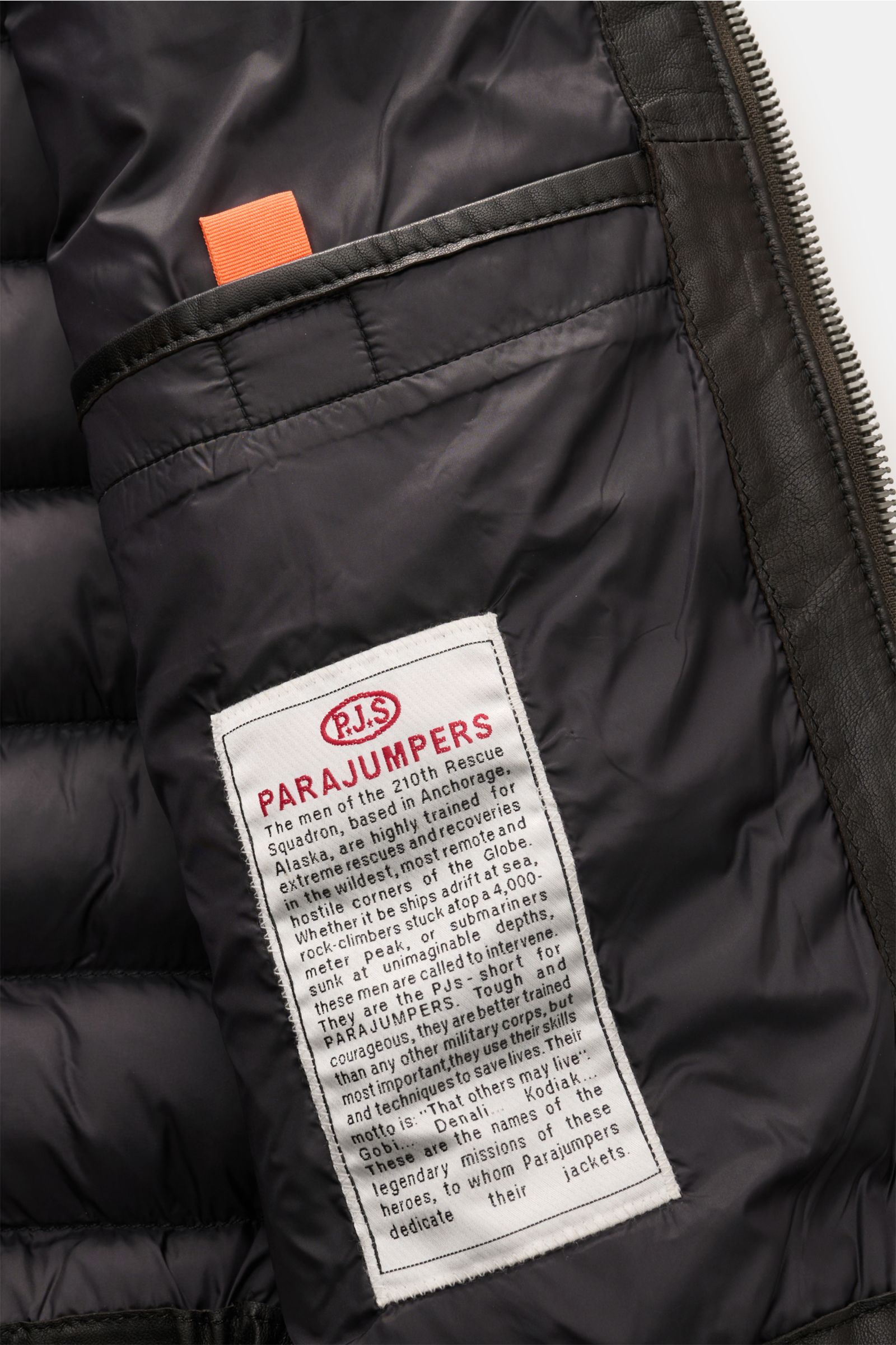 Close-up view of the inside lining of the Parajumpers Lederjacke 'Ernie' schwarz, showing the black quilted fabric and the white Parajumpers label with red and black text. Ein Hauch Abenteuer, verpackt in purem Luxus: Die Lederjacke 'Ernie' von PARAJUM