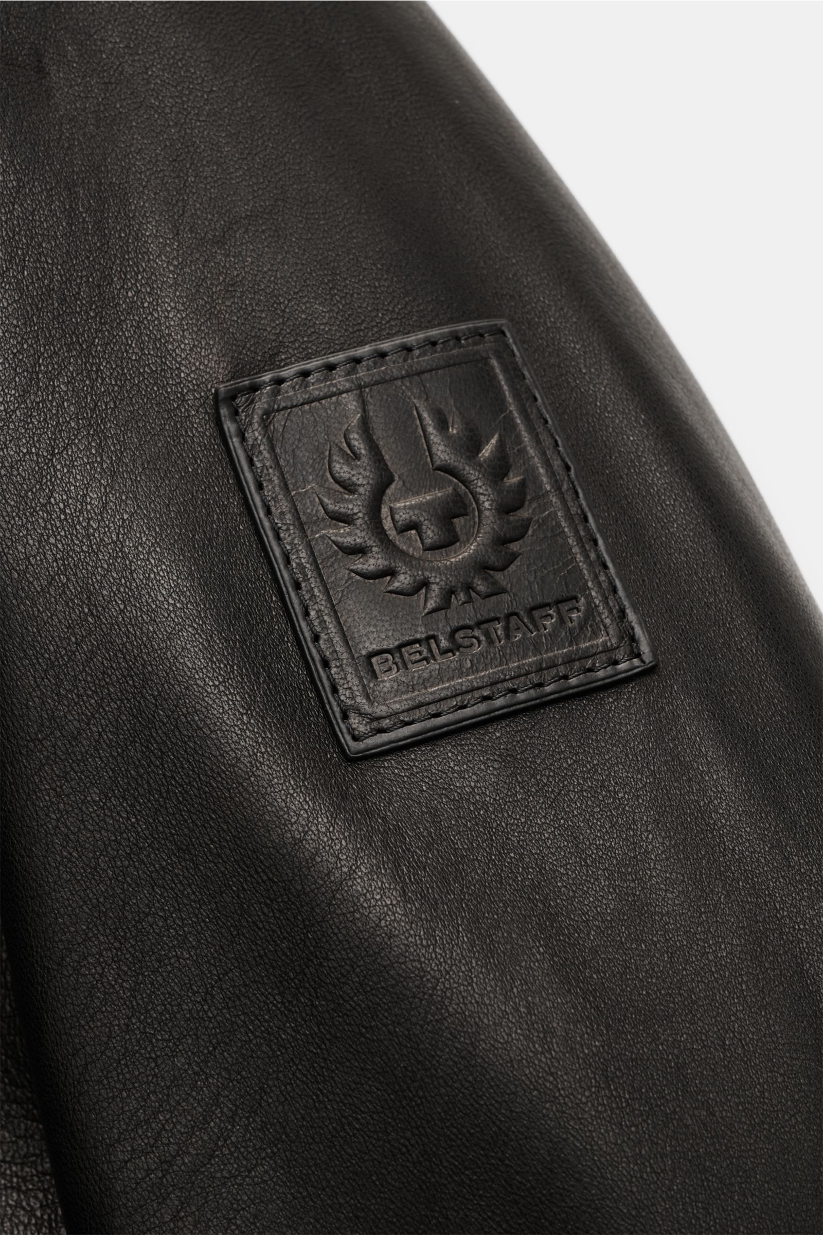 Belstaff Lederjacke 'Track Racer' schwarz, Detailaufnahme des BELSTAFF-Logos auf weichem Lammleder im modernen Biker-Look.