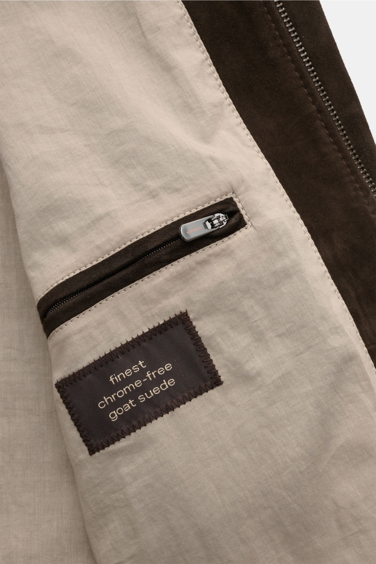 Close-up inside view of the Windsor Veloursleder Blouson 'Borello' navy showing the smooth beige lining, zippered inner pocket, and label stating finest chrome-free goat suede. Geschmeidiger Blouson: Die chromfrei gegerbte Lederjacke 'Borello' von WINDSOR