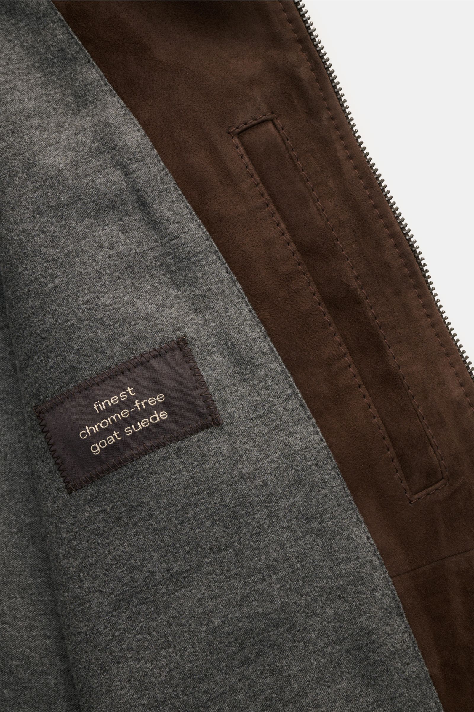 Close-up inside view of Windsor Veloursleder Blouson 'Borello' dunkelbraun showing soft chrome-free goat suede leather, fine zipper, and smooth grey lining.

Description: Geschmeidiger Blouson: Die chromfrei gegerbte Lederjacke 'Borello' von WINDSOR wu