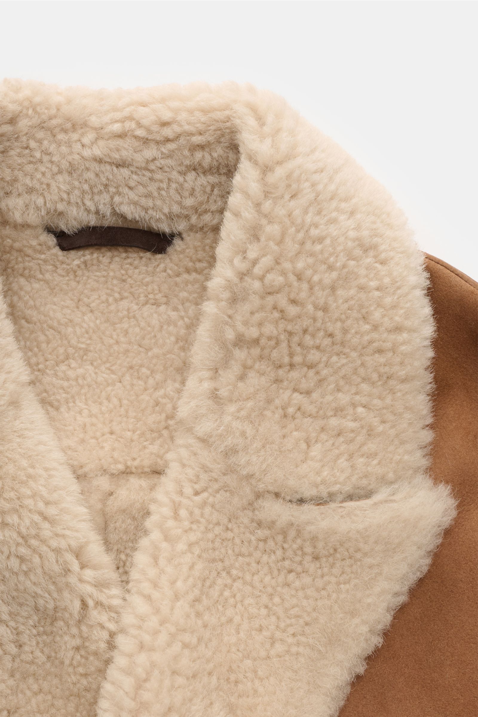 Manzoni 24 Lammfellmantel braun, Detailaufnahme von innen, weiches Lammveloursleder, Innenseite und Reverskragen aus warmem Lammfell, Slim Fit, zweireihige Knopfleiste, Taschen und Knopfärmel.