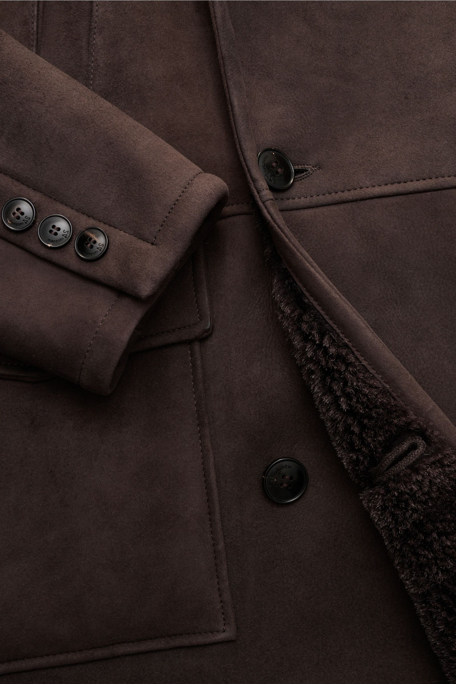 Manzoni 24 Lammfellmantel dunkelbraun aus reinem Lammvelours, weich, slim fit, zweireihig mit Knöpfen, Taschen, Revers und Lammfell-Innenseite, Detailansicht.