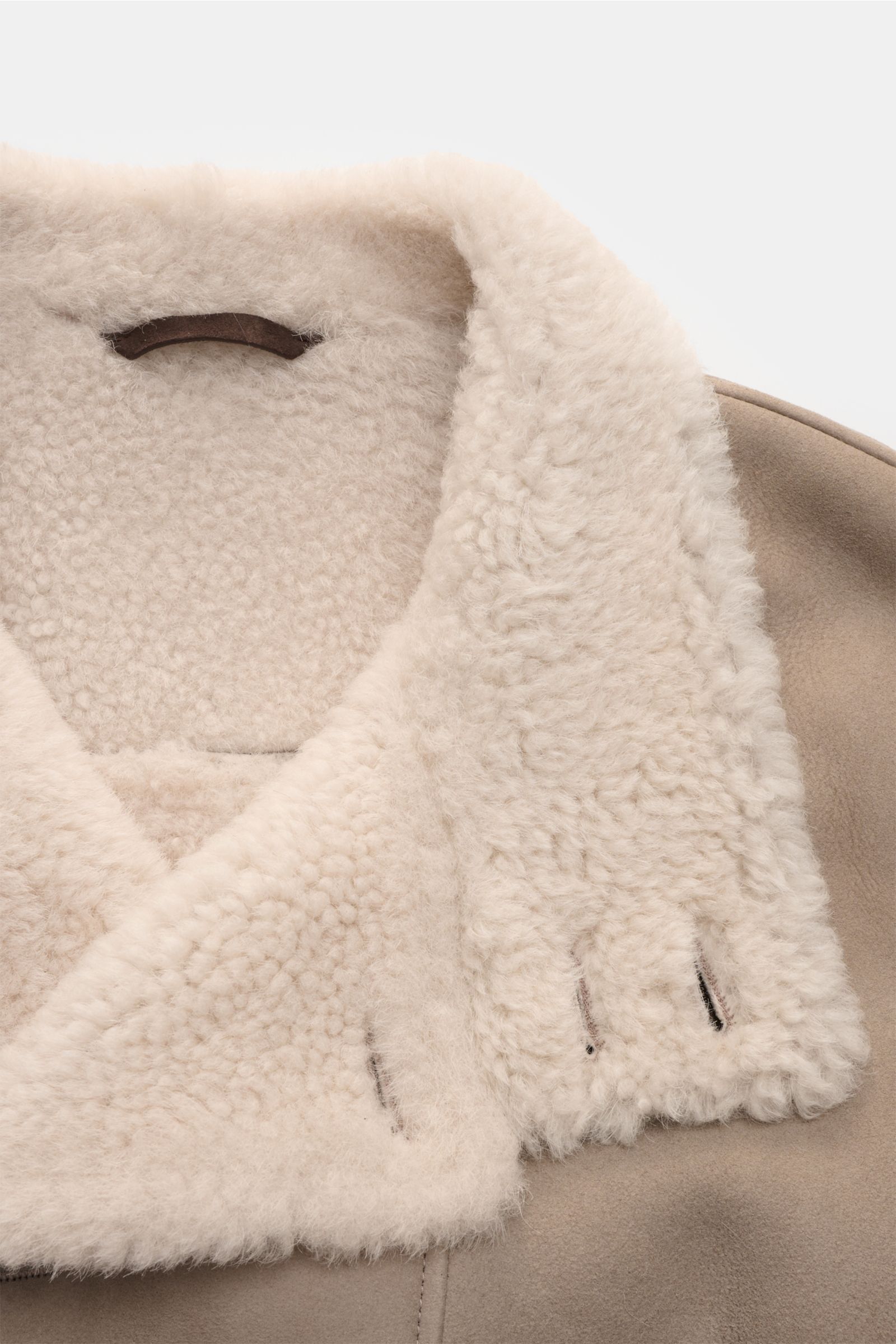 Close-up front top view of Manzoni 24 Lammfelljacke hellgrau showing soft beige lambswool collar and light grey lamb velour leather exterior. 

Description: Der Luxus von wärmendem Lammfell materialisiert sich in dieser Jacke von MANZONI 24 aus weichem