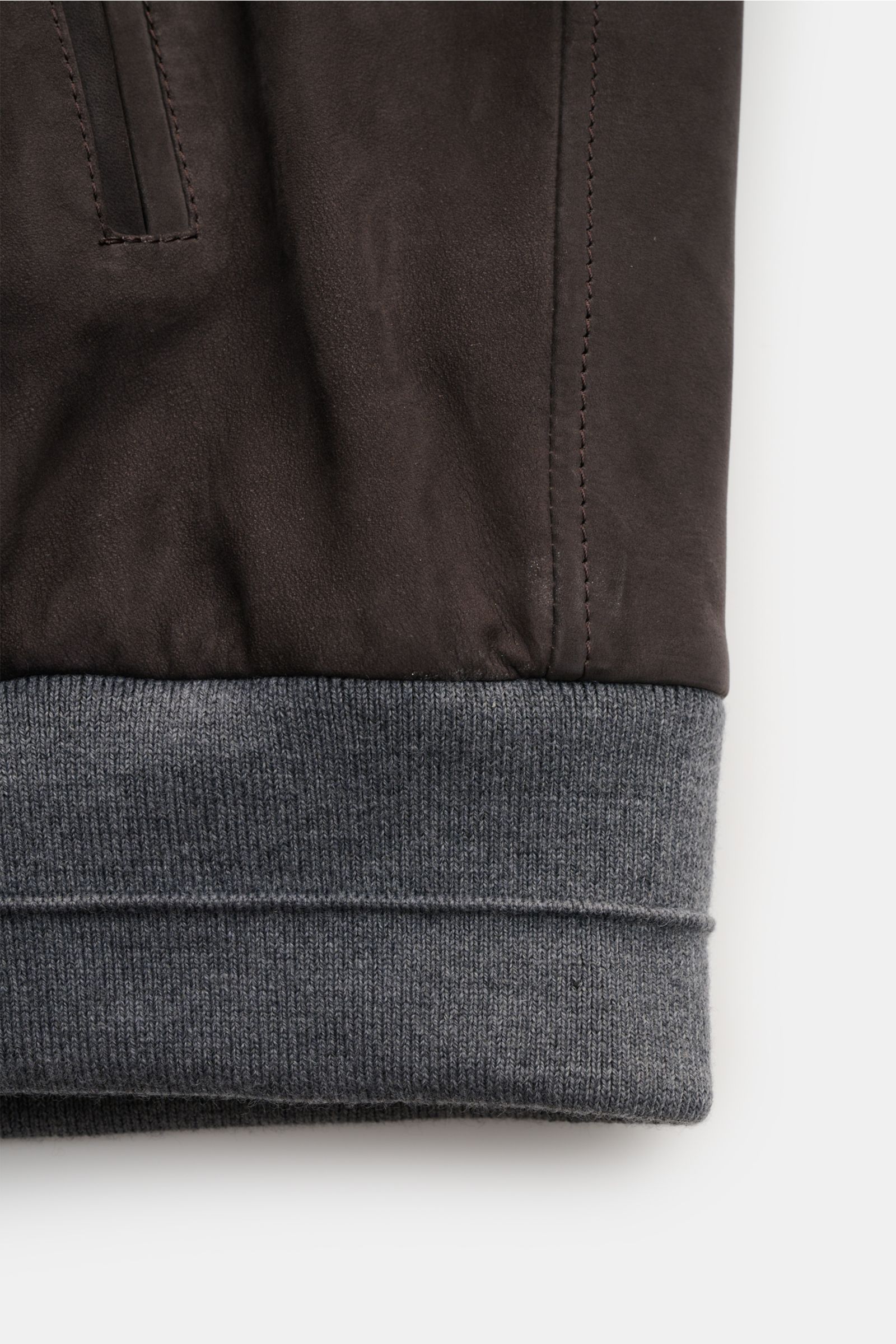 Close-up side view of the Manzoni 24 Veloursleder-Blouson graubraun showing grey ribbed elastic hem, soft grey-brown velour leather, and detailed stitching. Stilvoller Begleiter für die Übergangszeit: MANZONI 24 präsentiert mit diesem edlen Blouson ein lu
