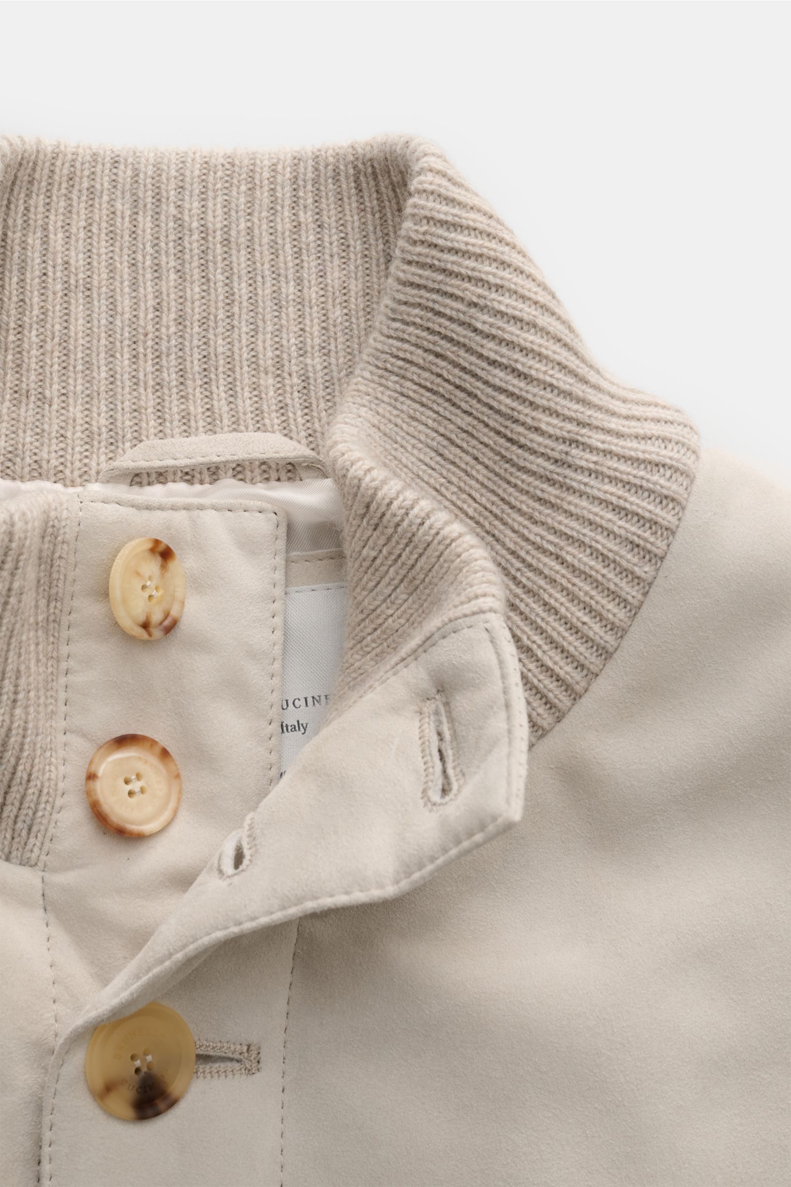 Close-up front view of Brunello Cucinelli Cashmere Strickblouson braun showing ribbed knit collar, nubuck leather front, and button details. Luxuriöser Cashmere-Strick trifft auf feinstes Nubukleder: Dieser exklusive Strickblouson von BRUNELLO CUCINELLI k