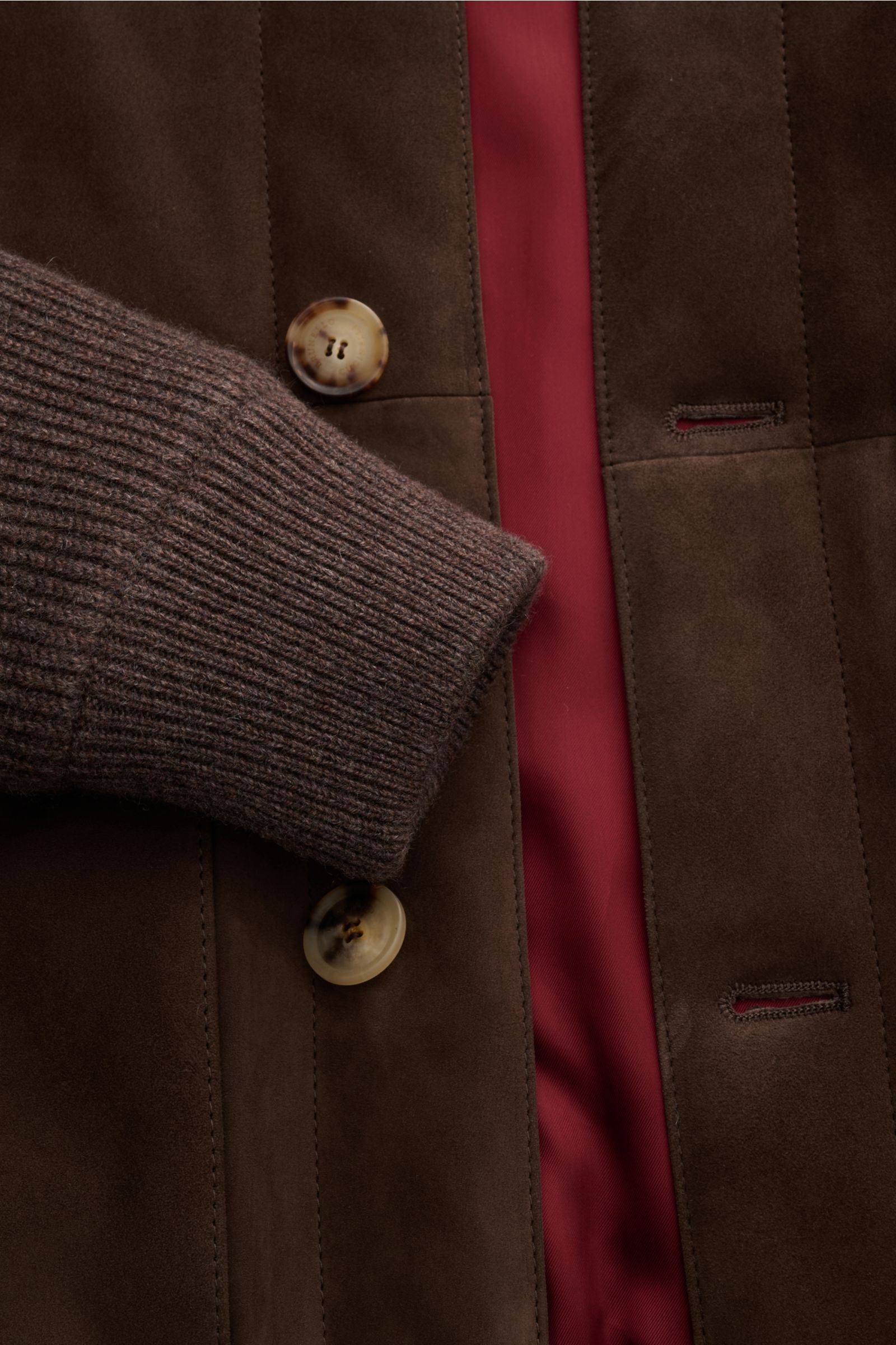 Close-up front view of the Brunello Cucinelli Cashmere Strickblouson grau showing soft ribbed cashmere cuff, fine nubuck leather front with button details, and red inner lining. Luxuriöser Cashmere-Strick trifft feinstes Nubukleder: Dieses edle Blouson
