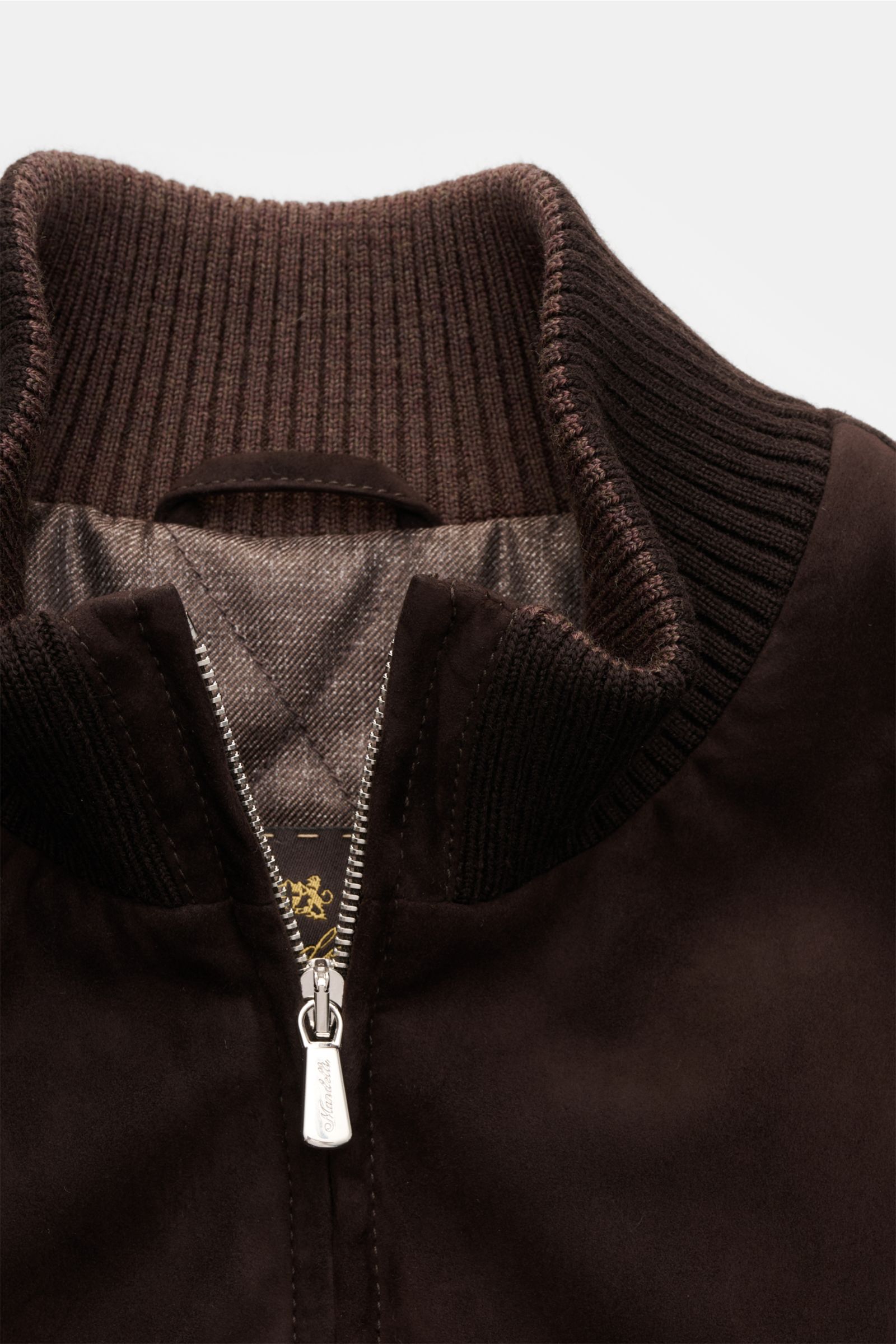 Close-up front view of the Mandelli Veloursleder-Blouson dunkelbraun showing the ribbed collar, two-way zipper, and soft dark brown goat suede with a slim fit design. Luxuriöser Komfort für die Übergangszeit: Der Veloursleder-Blouson von MANDELLI überzeug