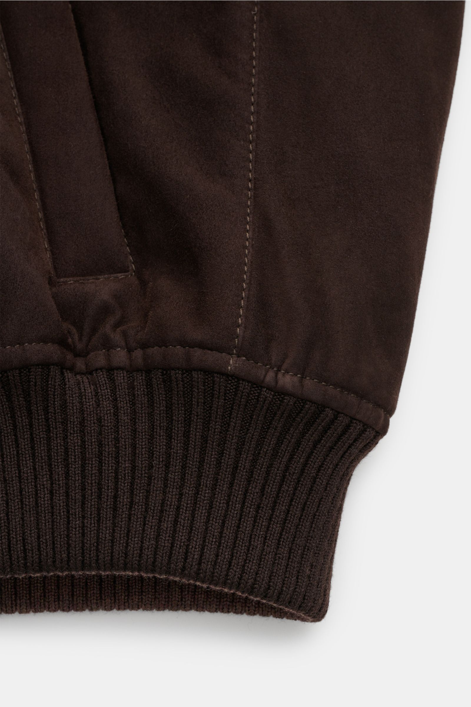 Close-up from the side of the cuff and pocket area of the Mandelli Veloursleder-Blouson dunkelbraun showing soft goat suede, elastic ribbed hem and sleeve cuffs.

Description: Luxuriöser Komfort für die Übergangszeit: Der Veloursleder-Blouson von MANDE