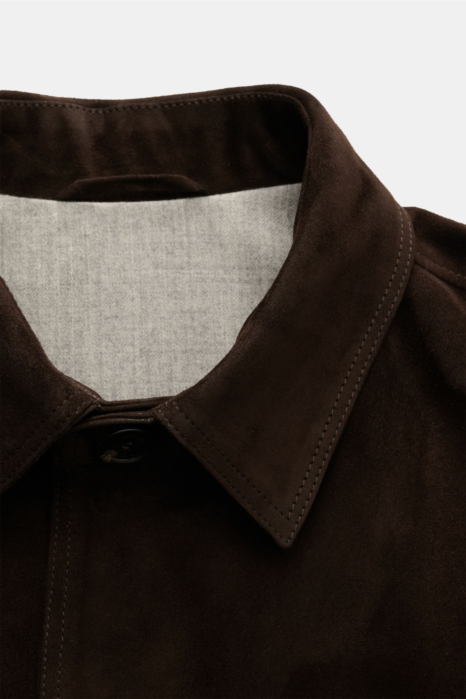 Nahaufnahme der Rifugio Velourslederjacke dunkelbraun von oben, zeigt Umlegekragen, weiches Veloursleder und wärmendes Wollfutter.