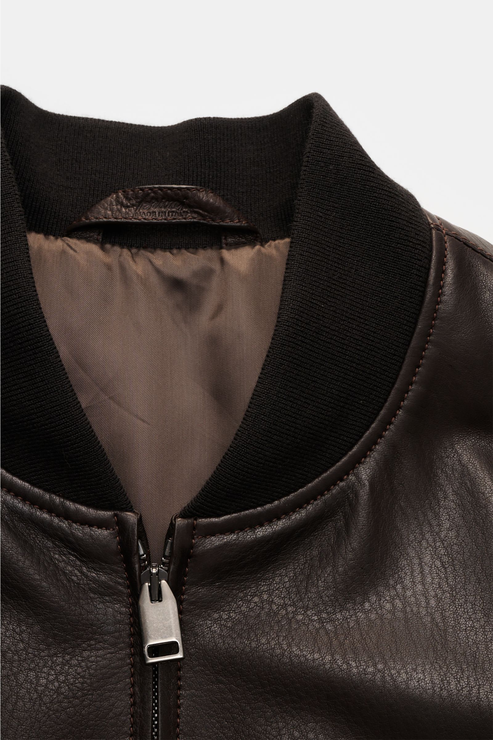 Close-up front view of Brioni Leather blouson 'Plad' dark brown, showing elegant lambskin leather, two-way zip, and ribbed collar.