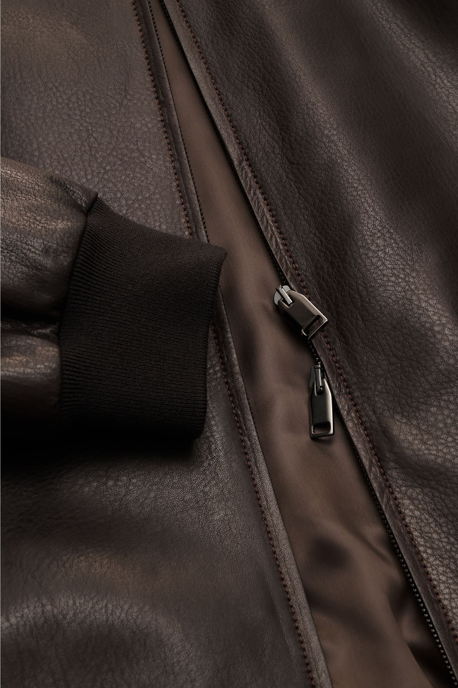 Close-up front view of Brioni Leather blouson 'Plad' dark brown in elegant lambskin with two-way zip, zip pockets, elastic cuffs, and smooth lining, showing craftsmanship details. A statement in fine craftsmanship: This leather blouson by BRIONI has a lux