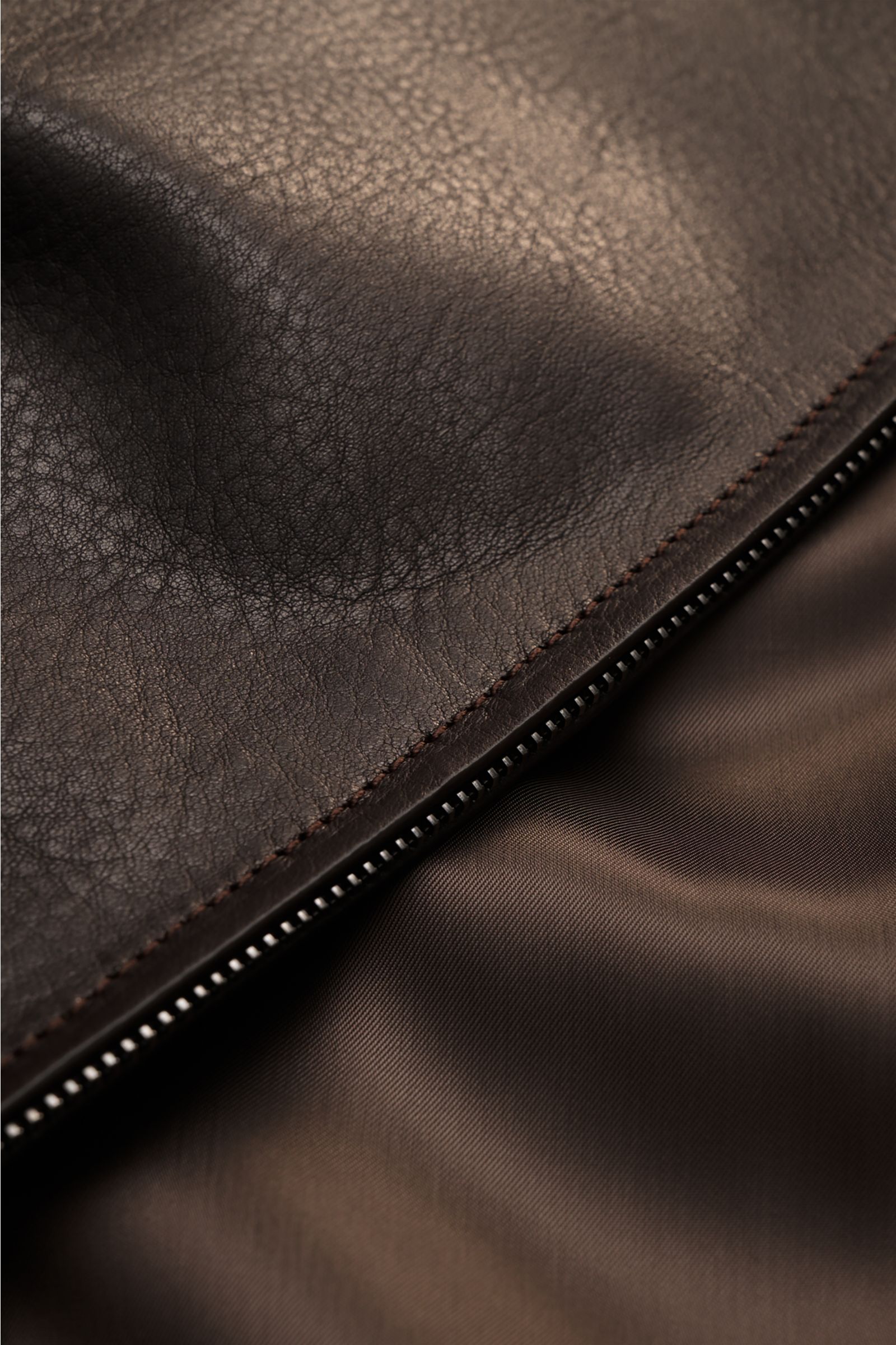 Close-up view of the dark brown Brioni Leather blouson 'Plad' showing elegant lambskin leather, smooth lining, and two-way zip details.
