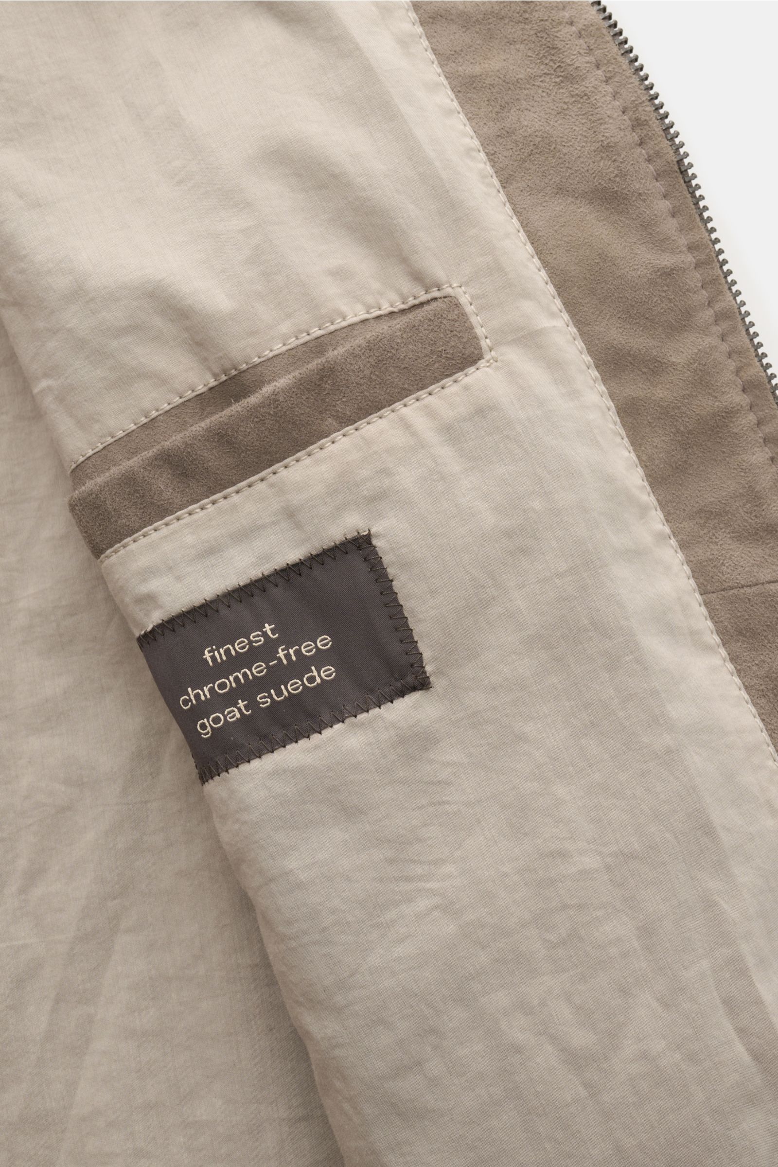 Innenansicht des Windsor Lederblouson 'Borello' taupe, Detailaufnahme der Innentasche mit chromfrei gegerbtem, softem Veloursleder und Label.