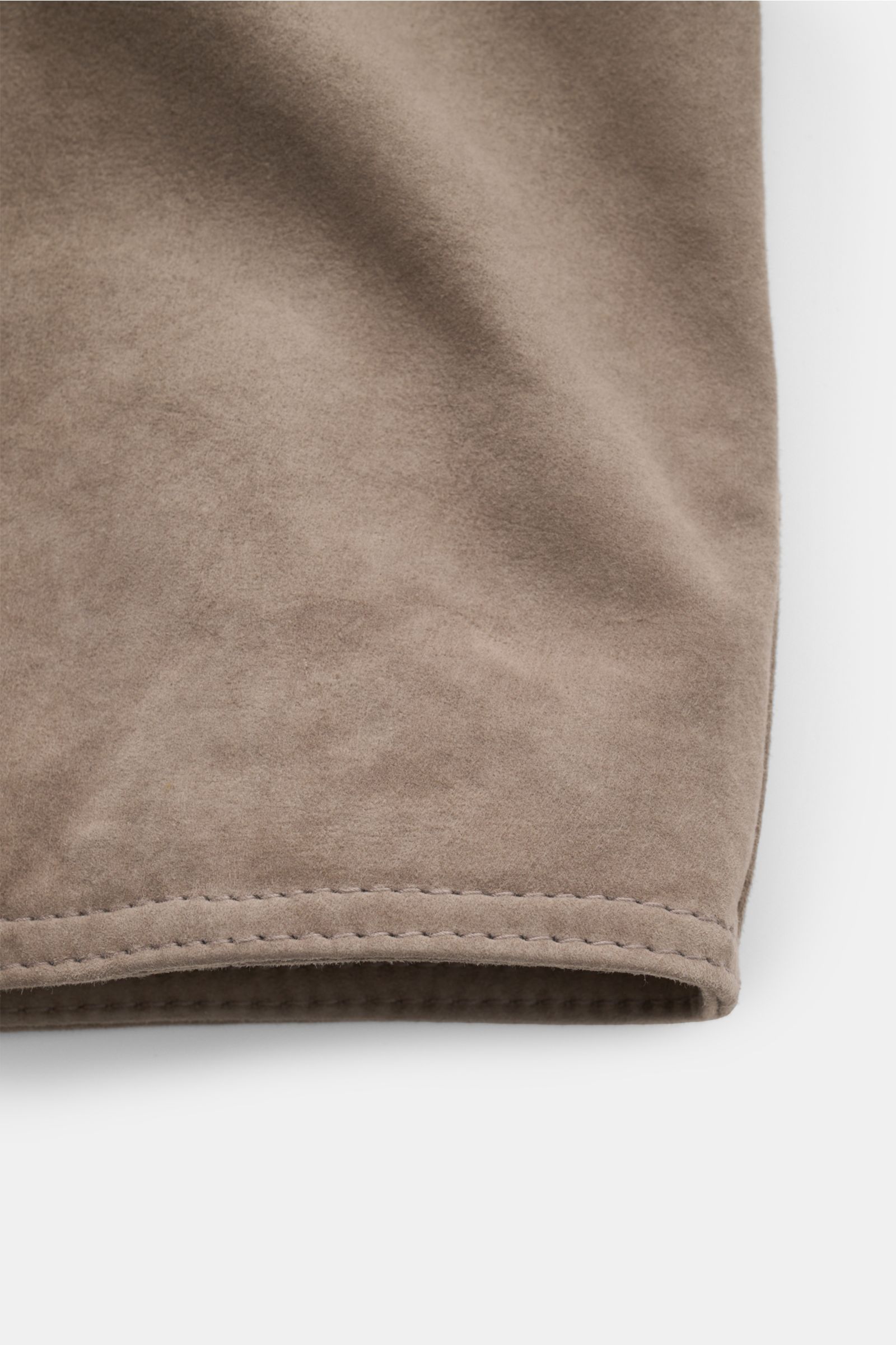 Nahaufnahme des Saums der Windsor Lederjacke 'Pesaro' taupe aus softem, chromfrei gegerbtem Veloursleder mit weichem Griff, Detail von Manschette mit Druckknopf, fotografiert aus seitlicher Perspektive.