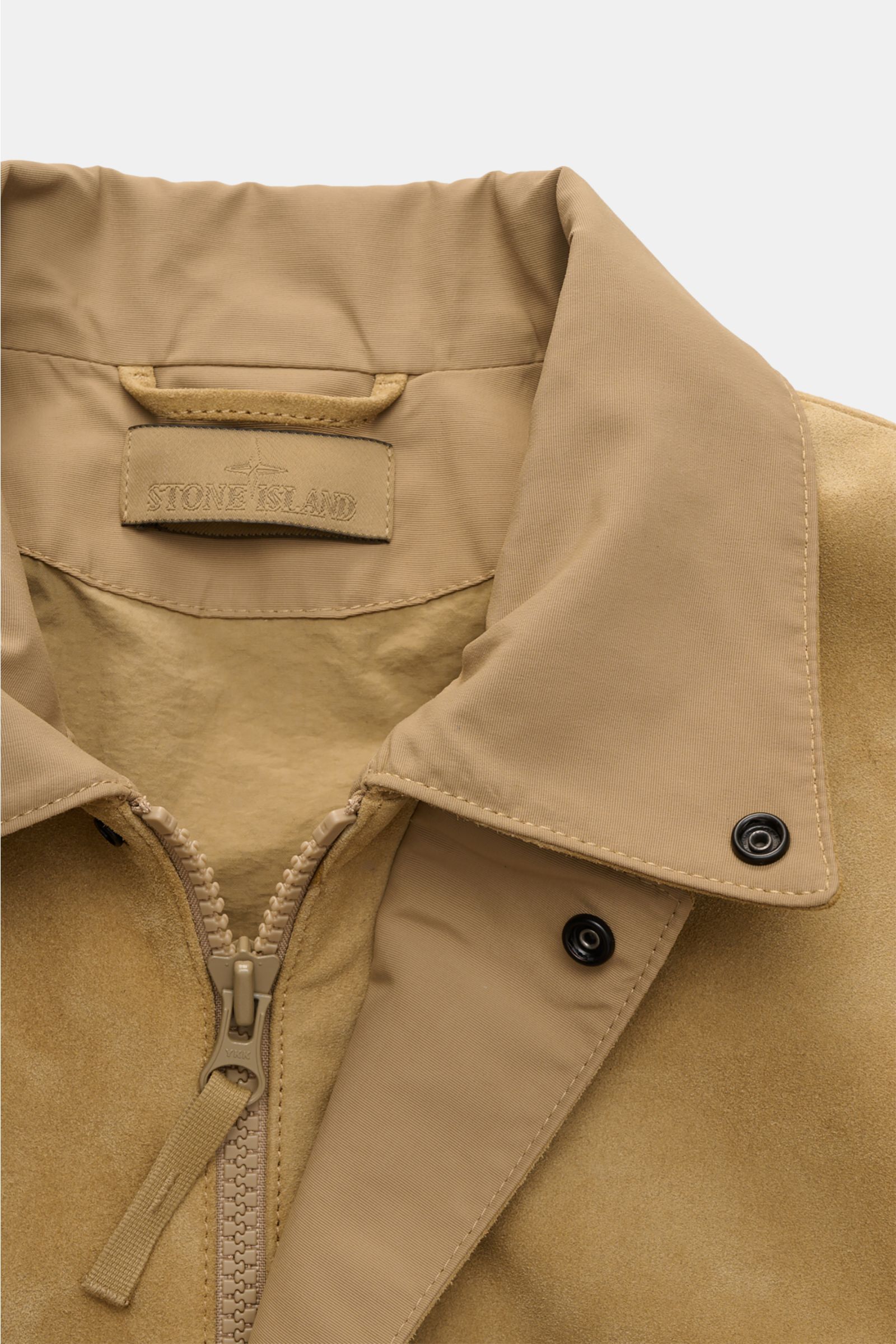 Close-up front view of Stone Island Suede jacket 'Ghost Piece' light brown featuring a turn-down collar, robust two-way zip, and snap buttons.

Description: Casual statement piece with authentic leather craftsmanship: The suede jacket 'Split Leather S.I. 