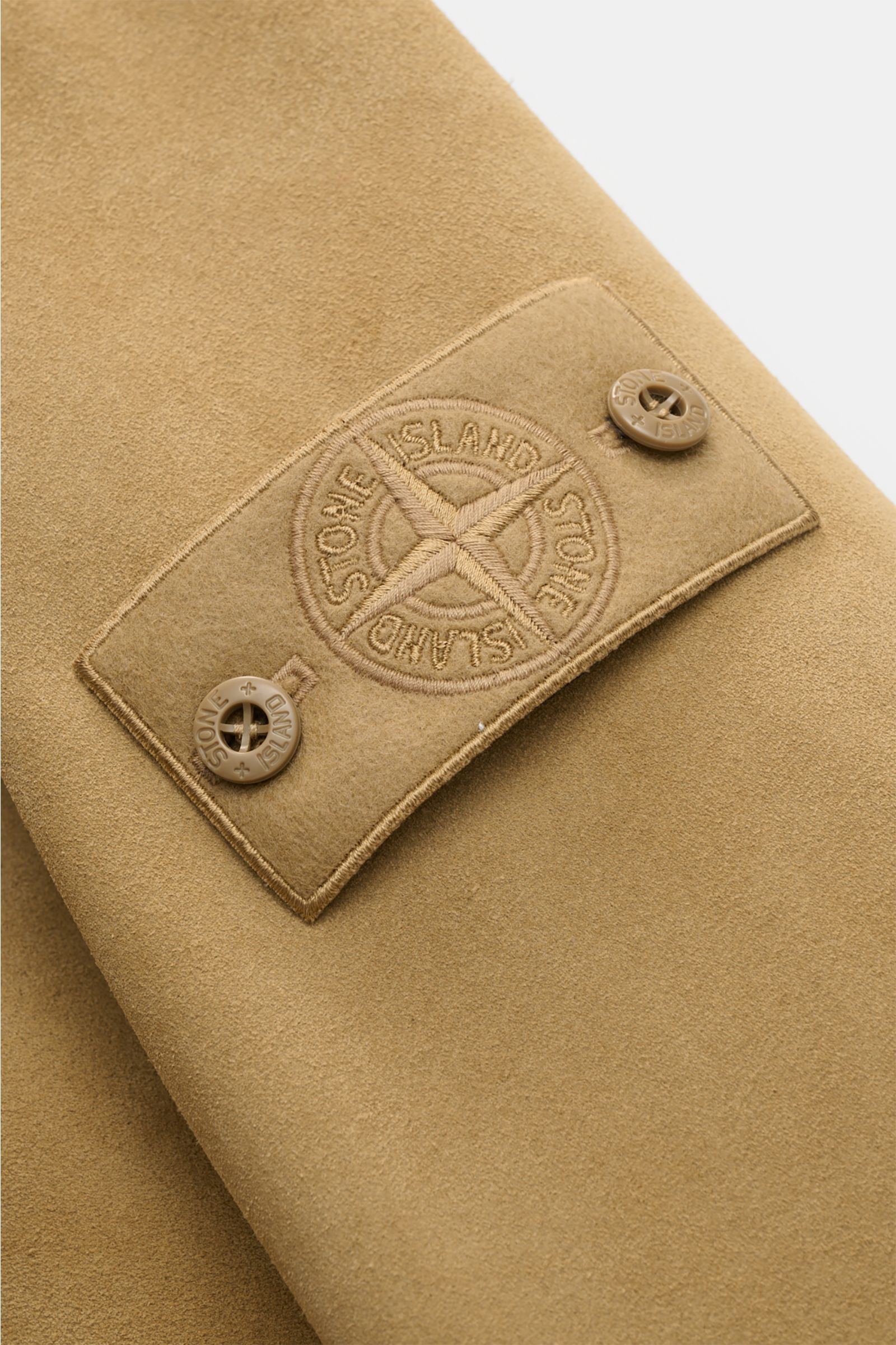 Close-up front sleeve view of Stone Island Suede jacket 'Ghost Piece' light brown with tonal compass badge and button details.

Description:  
Casual statement piece with authentic leather craftsmanship: The suede jacket 'Split Leather S.I. Ghost' from