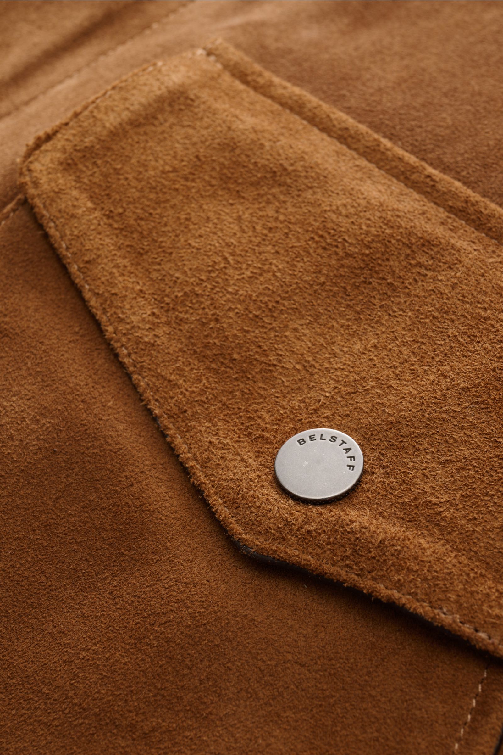Close-up front pocket detail of the Belstaff Suede jacket 'Outland' brown, showcasing supple suede, soft feel, and snap button.

Description: An urban classic for spring: The suede jacket 'Outland' by BELSTAFF is a stylish, eye-catching piece for the new 