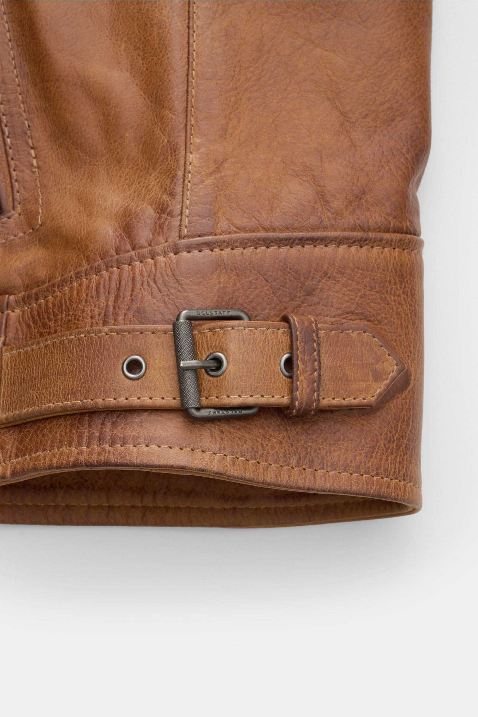 Nahaufnahme des Saumriemens mit Dornschließe aus robustem Metall der Belstaff Lederjacke 'Legacy Outlaw' braun aus handgewachstem Kalbleder.