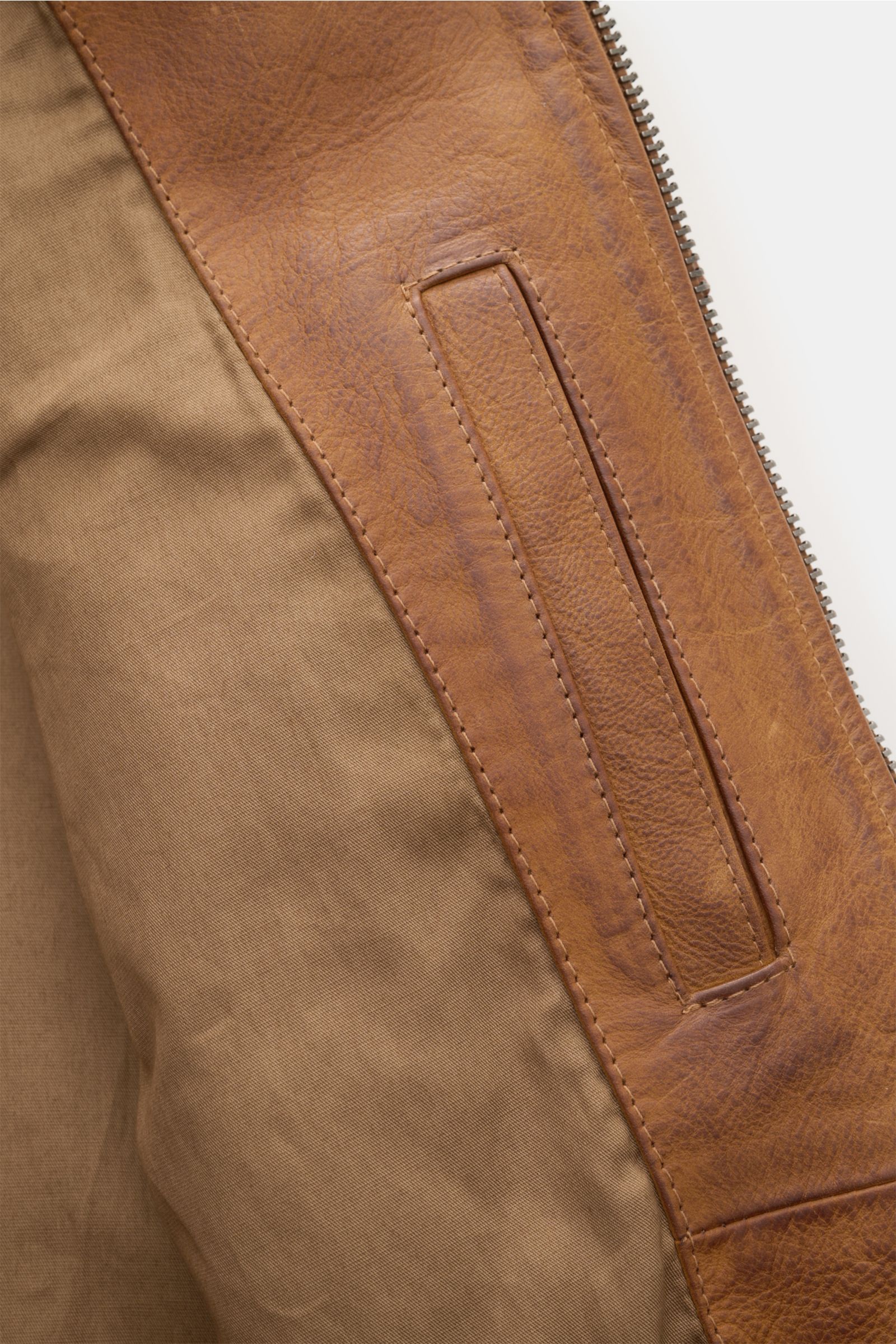 Nahaufnahme der Innentasche der Belstaff Lederjacke 'Legacy Outlaw' braun aus handgewachstem, wasserabweisendem Kalbleder mit Slim Fit und Metall-Reißverschluss.