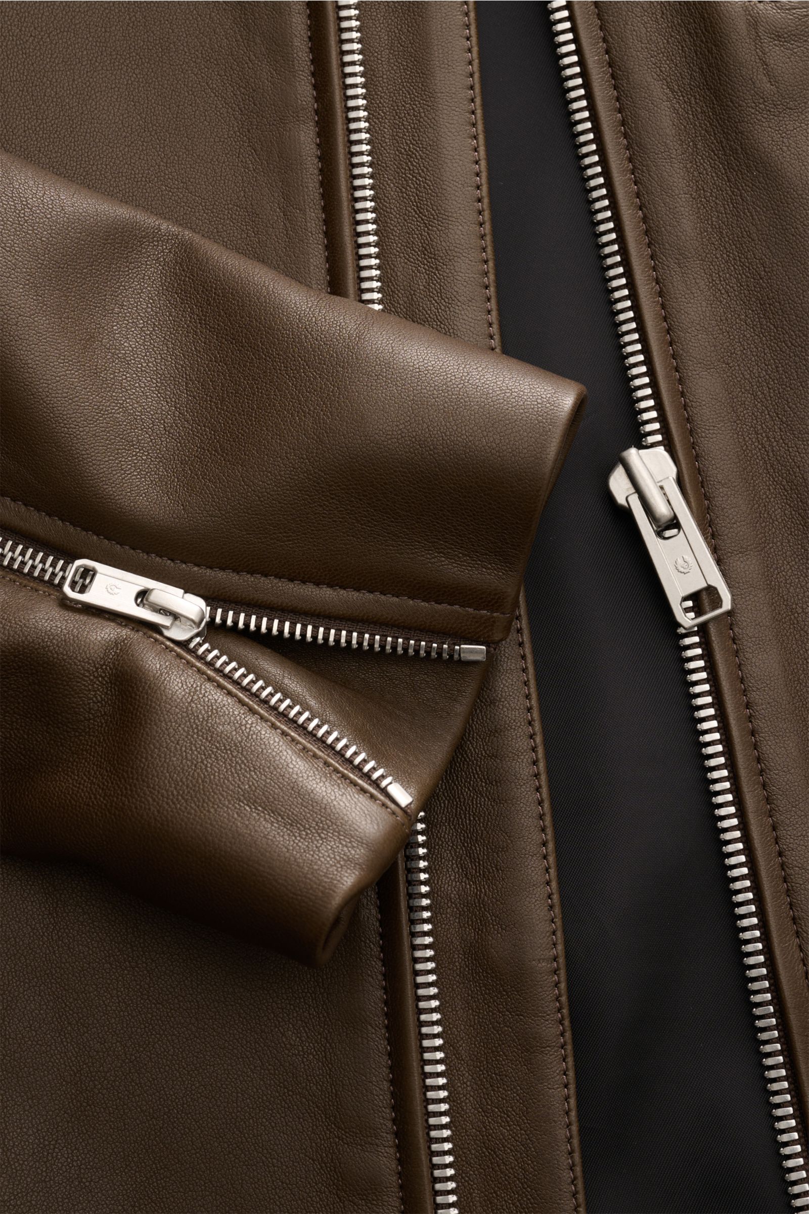Close-up front view of Belstaff Leather jacket 'Track Racer' dark brown in soft lambskin, showcasing robust metal zips and slim fit details.

A clean biker look from BELSTAFF: The leather jacket 'Track Racer' in soft lambskin embodies the spirit of adv