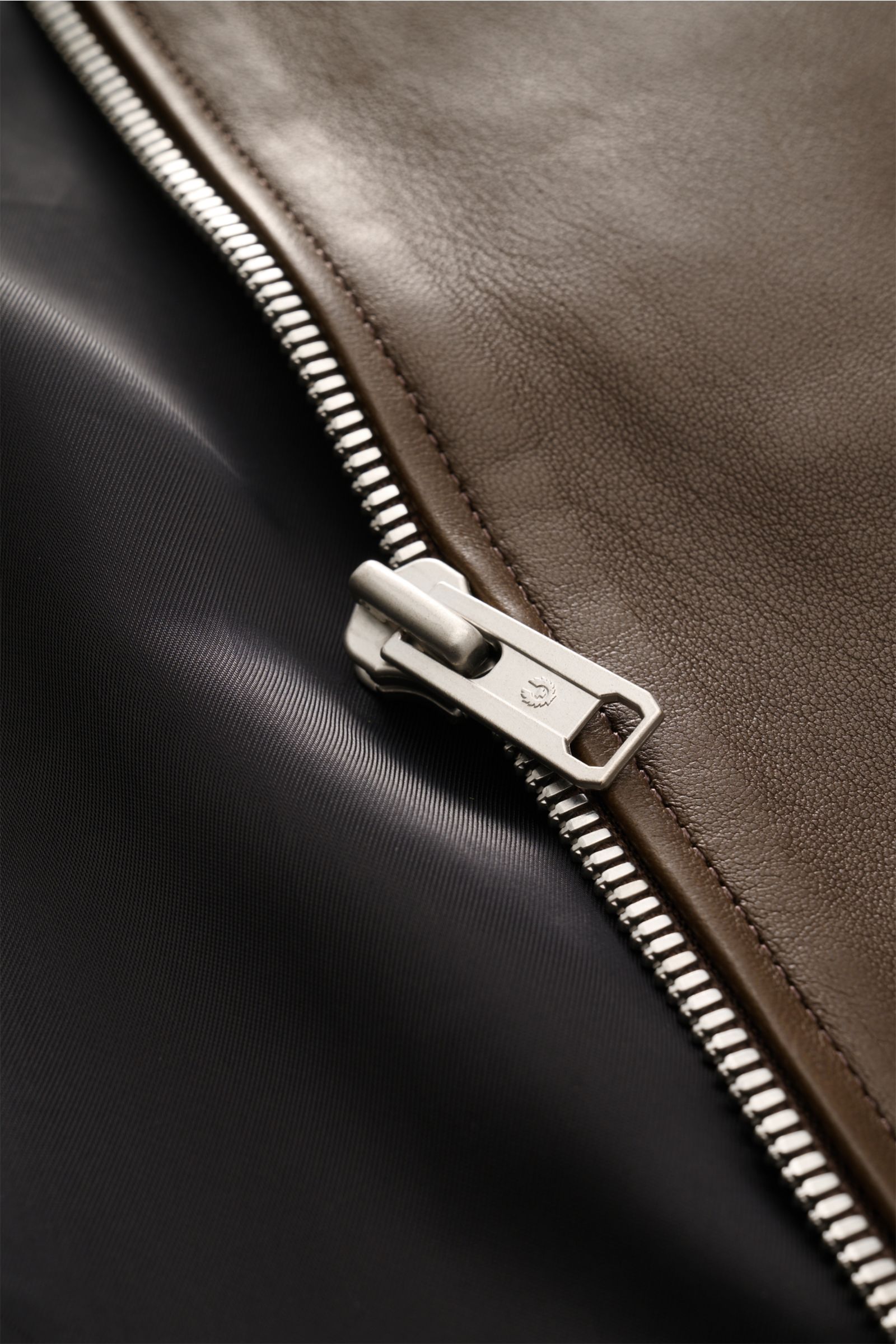 Close-up front view of the Belstaff Leather jacket 'Track Racer' dark brown showcasing supple lambskin, robust metal zip, and smooth black lining. 

A clean biker look from BELSTAFF: The leather jacket 'Track Racer' in soft lambskin embodies the spirit