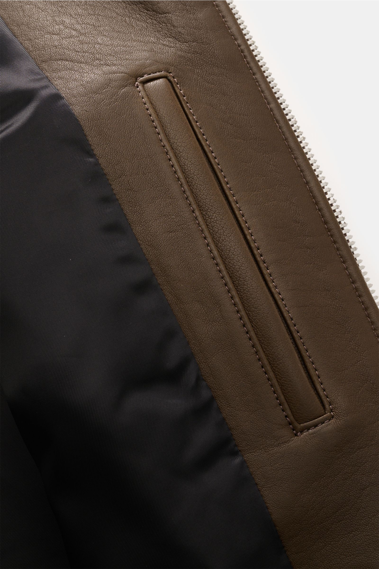 Close-up interior view of Belstaff Leather jacket 'Track Racer' dark brown showing supple lambskin, smooth black lining, and zippered pocket detail.

A clean biker look from BELSTAFF: The leather jacket 'Track Racer' in soft lambskin embodies the spiri