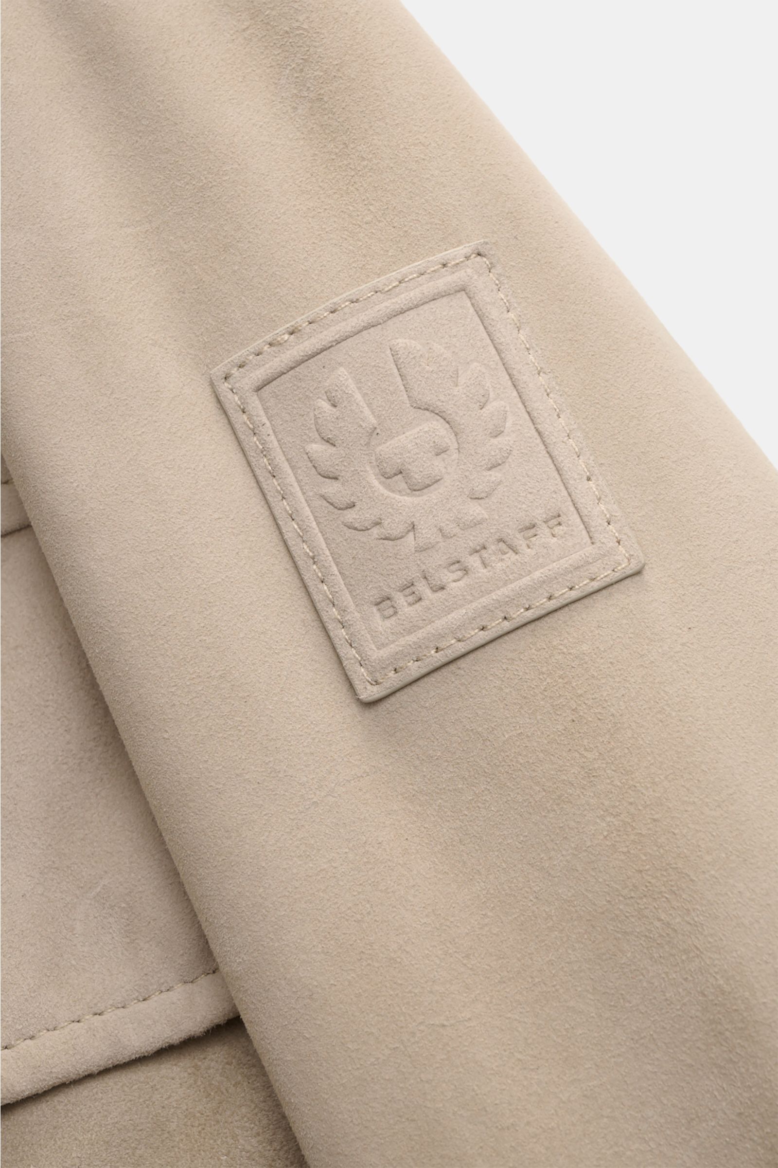 Close-up front-side view of the Belstaff Suede jacket 'Waymark' sand, showcasing its supple suede texture and embossed BELSTAFF label on the upper sleeve.

A versatile piece in supple suede: The hybrid 'Waymark' by BELSTAFF is a cool alternative piece,