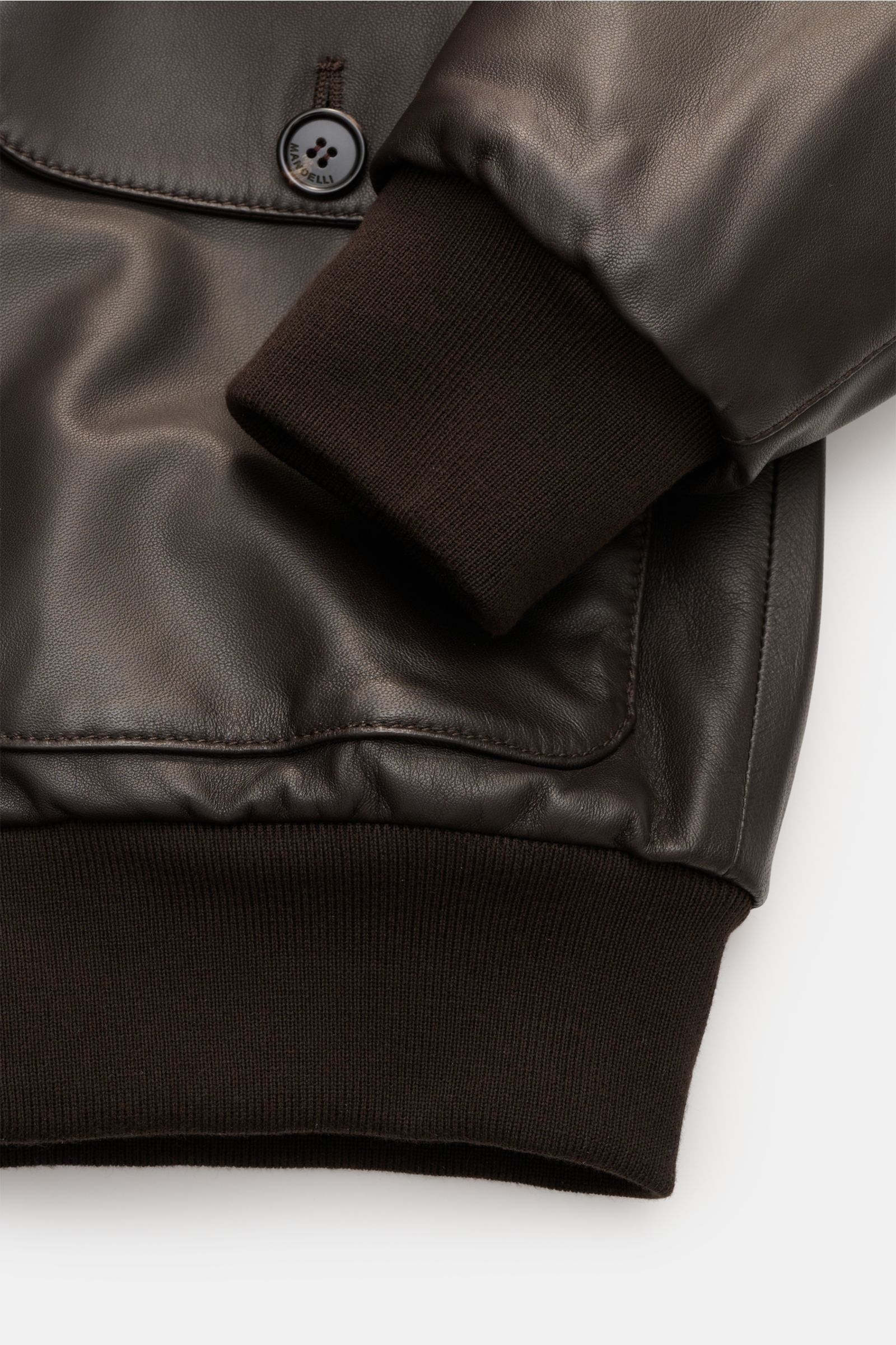 Nahaufnahme des Mandelli Lederblouson dunkelbraun mit geschmeidigem Lammleder, elastischem Ärmel- und Saumbündchen, Slim Fit, Sechs-Knopf-Leiste und Umlegekragen.