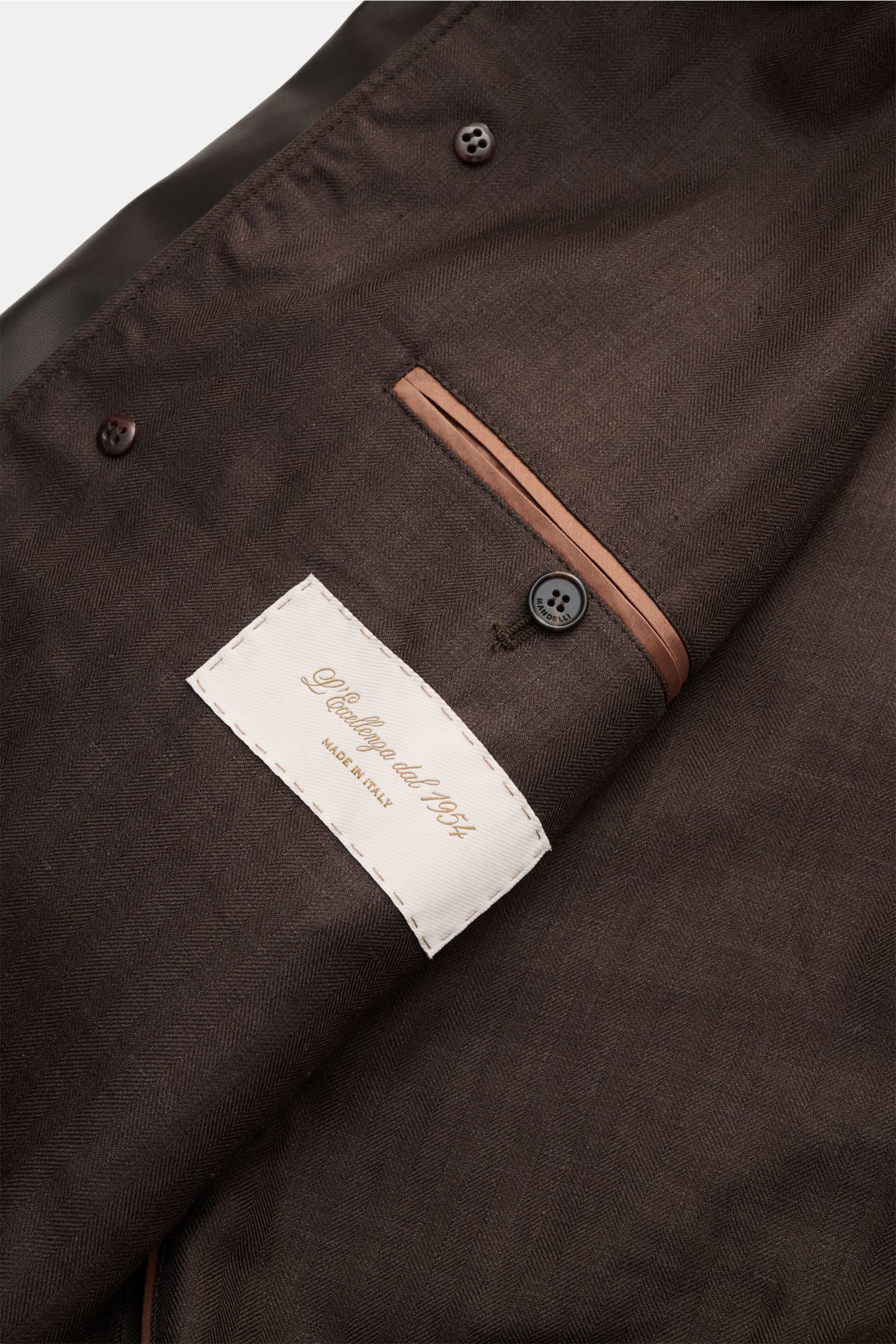 Innenansicht des Mandelli Lederblouson dunkelbraun mit geschmeidigem Futterstoff, Innentasche, Knöpfen und edlem Label.