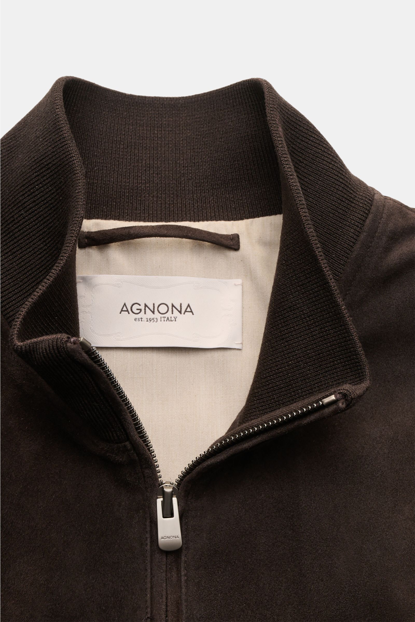 A close-up front view of the Agnona Suede blouson dark brown, showcasing the high-closing ribbed cotton-silk collar, premium suede with a smooth touch, and the concealed two-way zip with Agnona metal pull. A blouson that combines a confident, casual air a