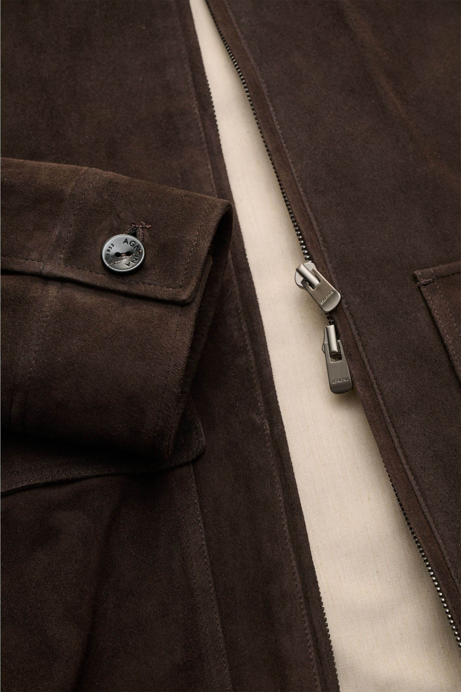 Close-up front view of the Agnona Suede blouson dark brown showcasing premium suede texture, slim fit, buttoned cuff, patch pocket, and concealed two-way zip. A blouson that combines a confident, casual air and luxurious material: This model in suede by A