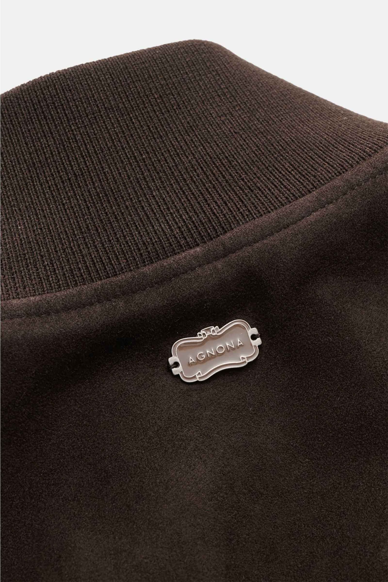 Close-up rear view of Agnona Suede blouson dark brown showing ribbed cotton-silk collar and silver metal emblem on premium suede.

Detailed description: A blouson that combines a confident, casual air and luxurious material: This model in suede by AGNONA 