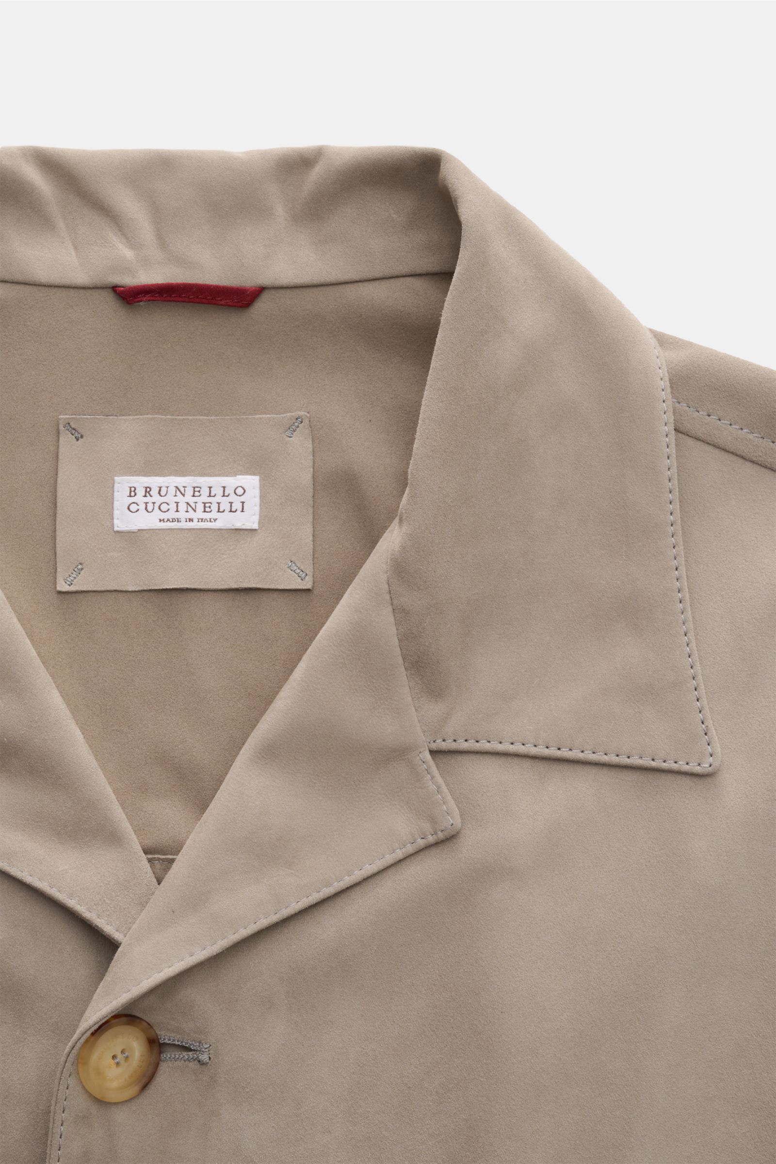 Nahaufnahme der Brunello Cucinelli Velourslederjacke beige aus samtigem Veloursleder, Slim Fit, kurzer Reverskragen und Fünf-Knopf-Leiste.