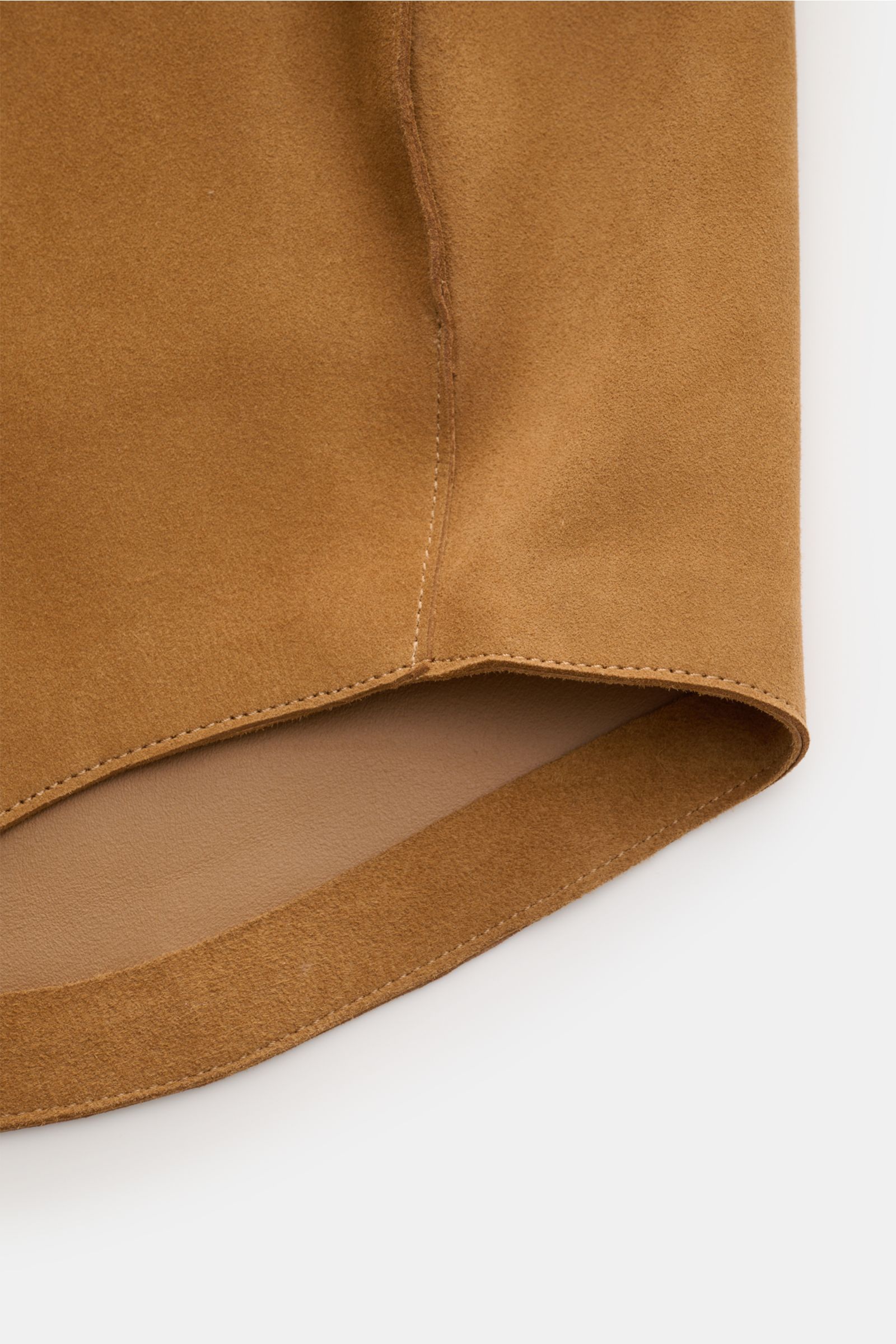 Close-up view of the rounded hemline of the Ami Paris Veloursleder-Overshirt camel, showcasing soft camel suede with neat stitching and smooth edges. Urban und lässig: Dieses Overshirt aus edlem Veloursleder von AMI PARIS ist ein Hingucker und lässt sich 