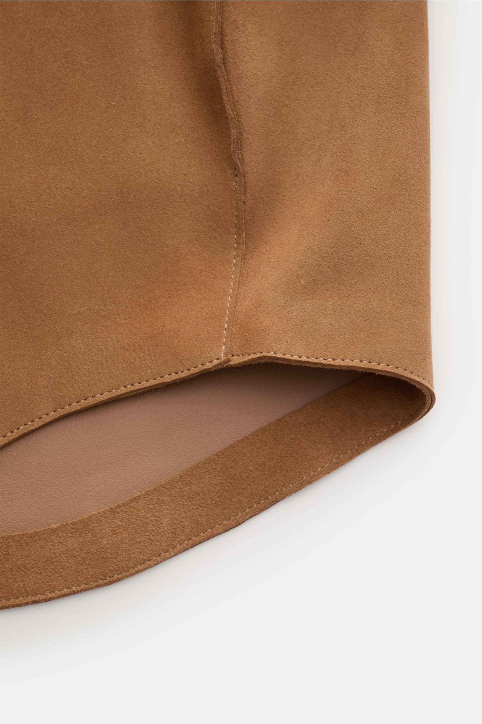 Close-up bottom hem view of Ami Paris Veloursleder-Overshirt camel, showcasing soft camel suede, rounded hem, and fine stitching. Urban und lässig: Dieses Overshirt aus edlem Veloursleder von AMI PARIS ist ein Hingucker und lässt sich perfekt zu Jeans und