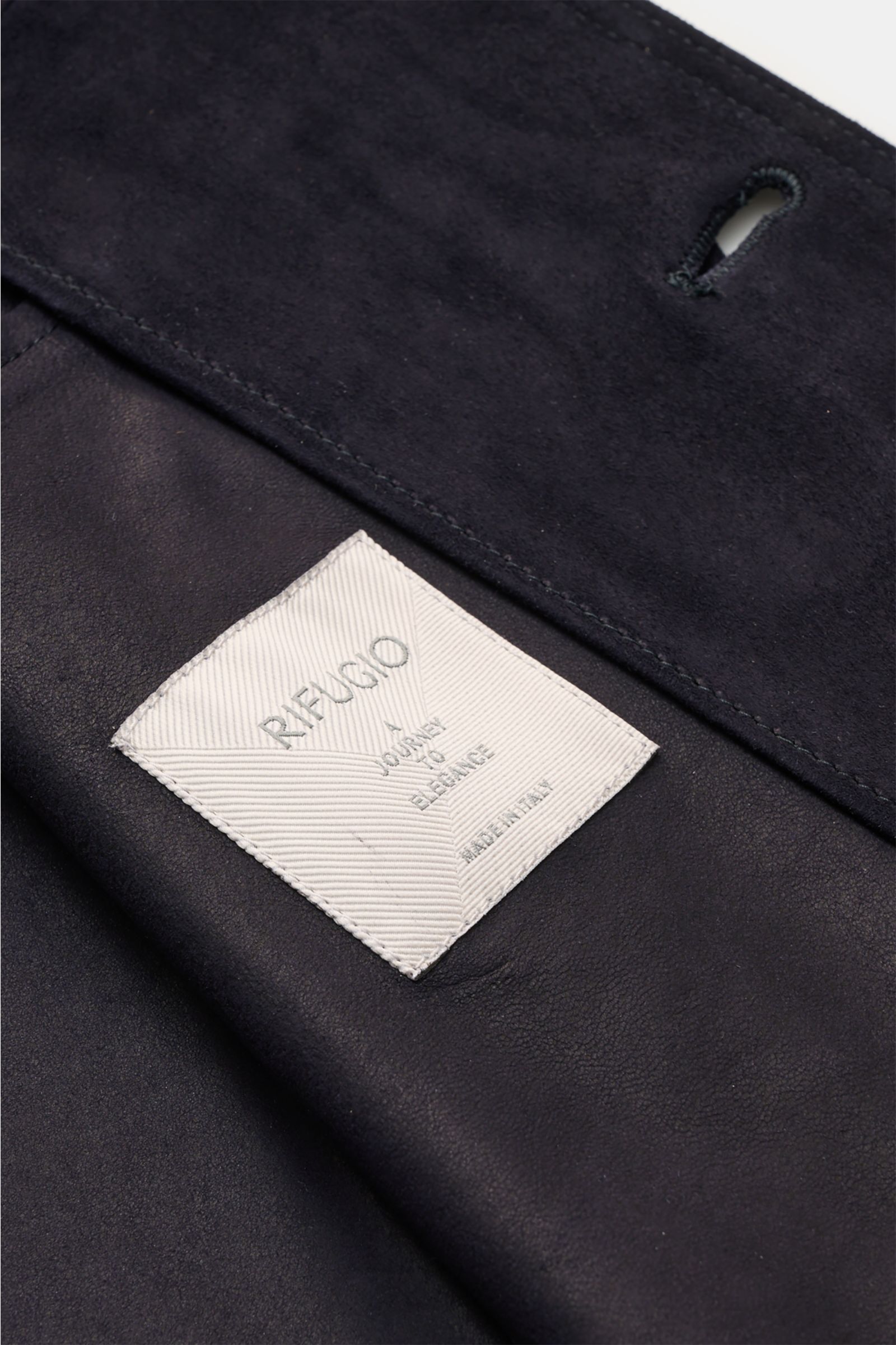 Nahaufnahme der Rifugio Velourslederjacke schwarz mit samtig-weichem Griff, unconstructed Design und elegantem Etikett.