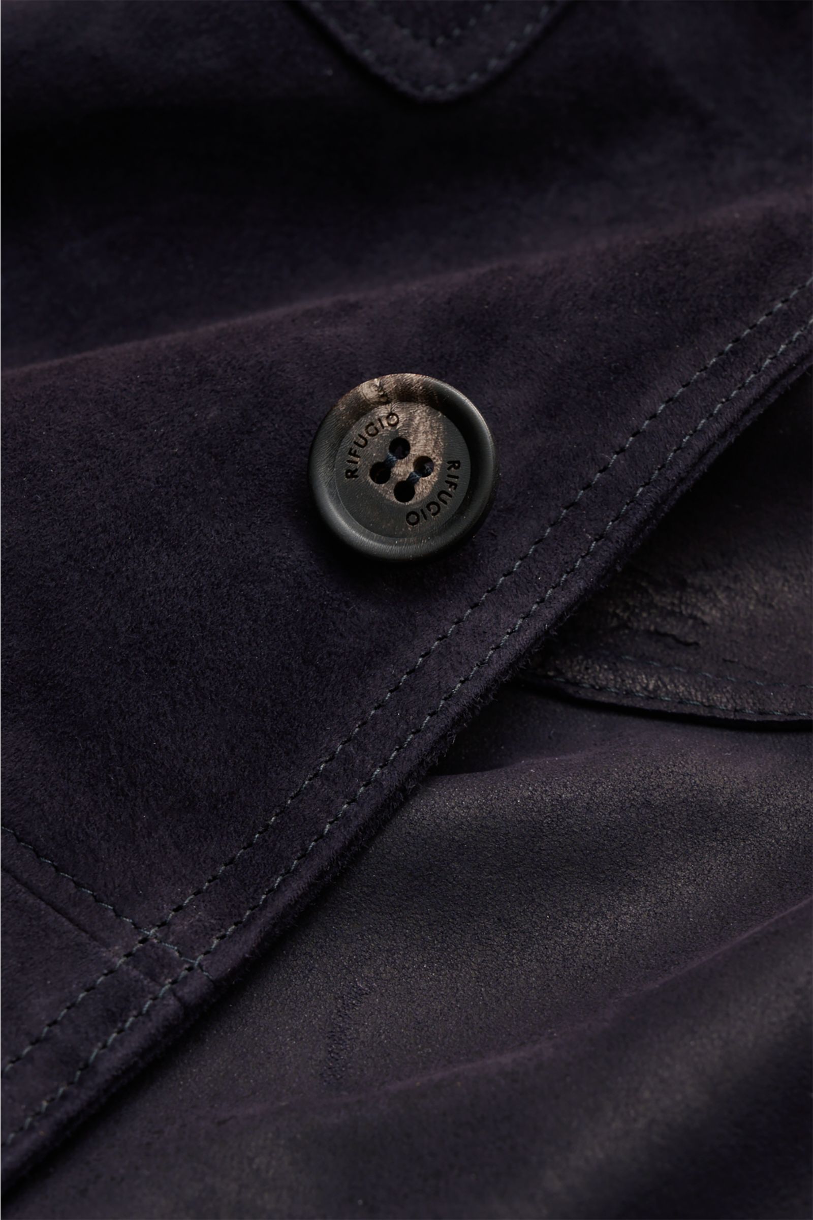Nahaufnahme der schwarzen Rifugio Velourslederjacke mit samtig-weichem Griff, sichtbarem Knopf und feiner Naht im Slim Fit.