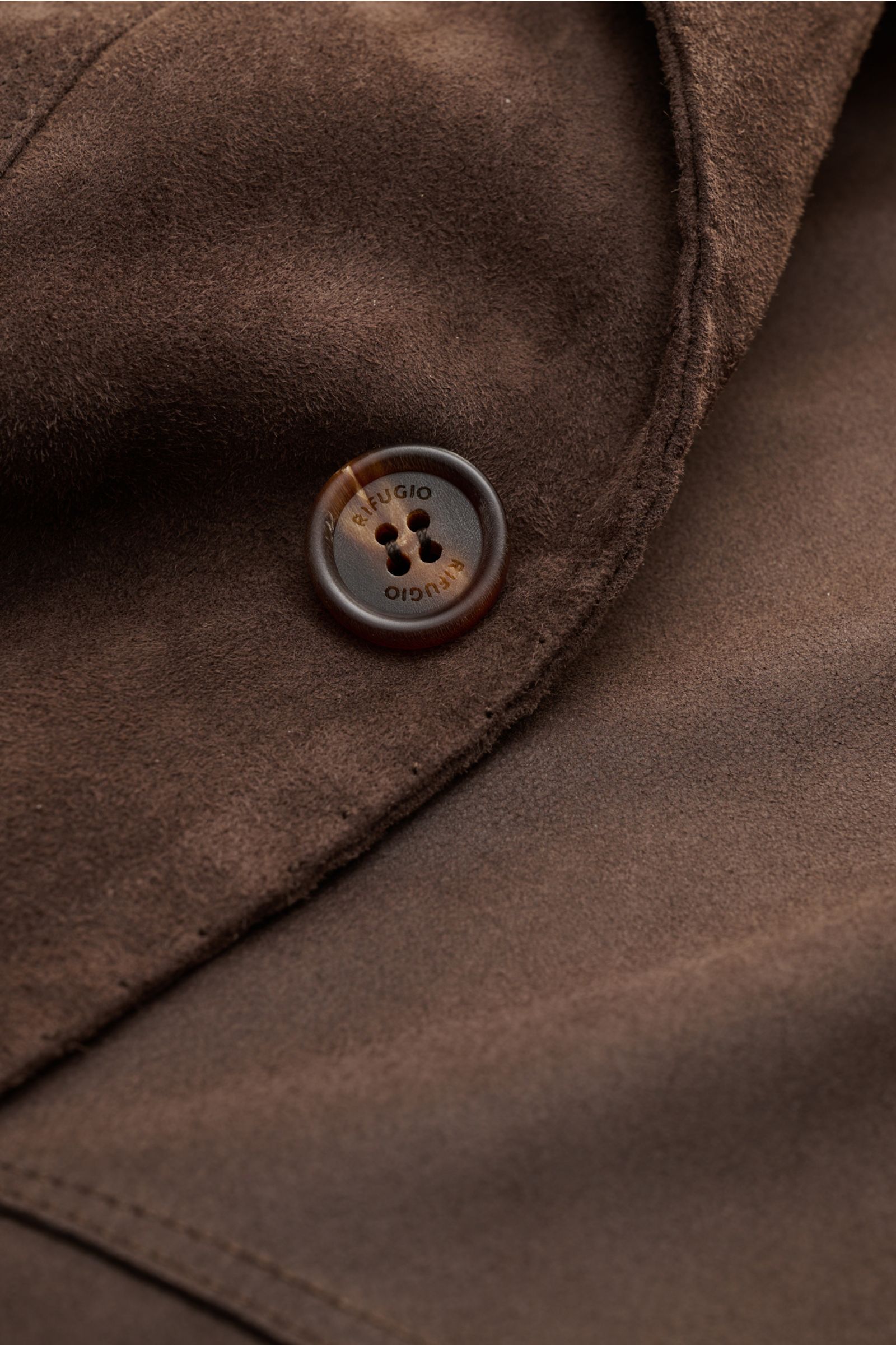 Close-up front view of Rifugio Suede jacket dark brown showing soft, supple suede, branded button, and fine stitching in slim fit design.