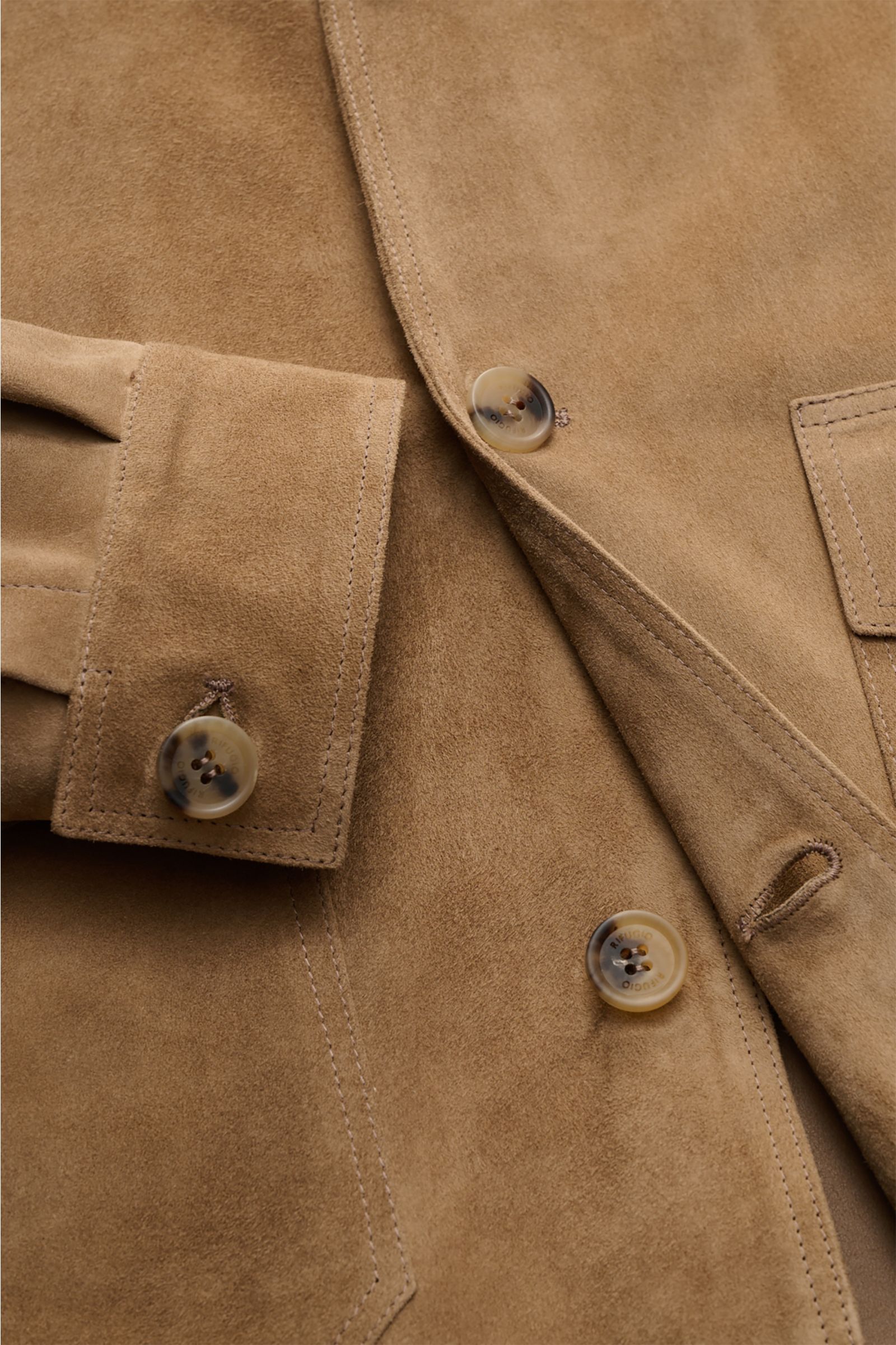 Nahaufnahme der Rifugio Velourslederjacke hellbraun aus samtig-weichem Veloursleder, Slim Fit, Fünf-Knopf-Leiste, Manschettenärmel, Umlegekragen und aufgesetzten Taschen.