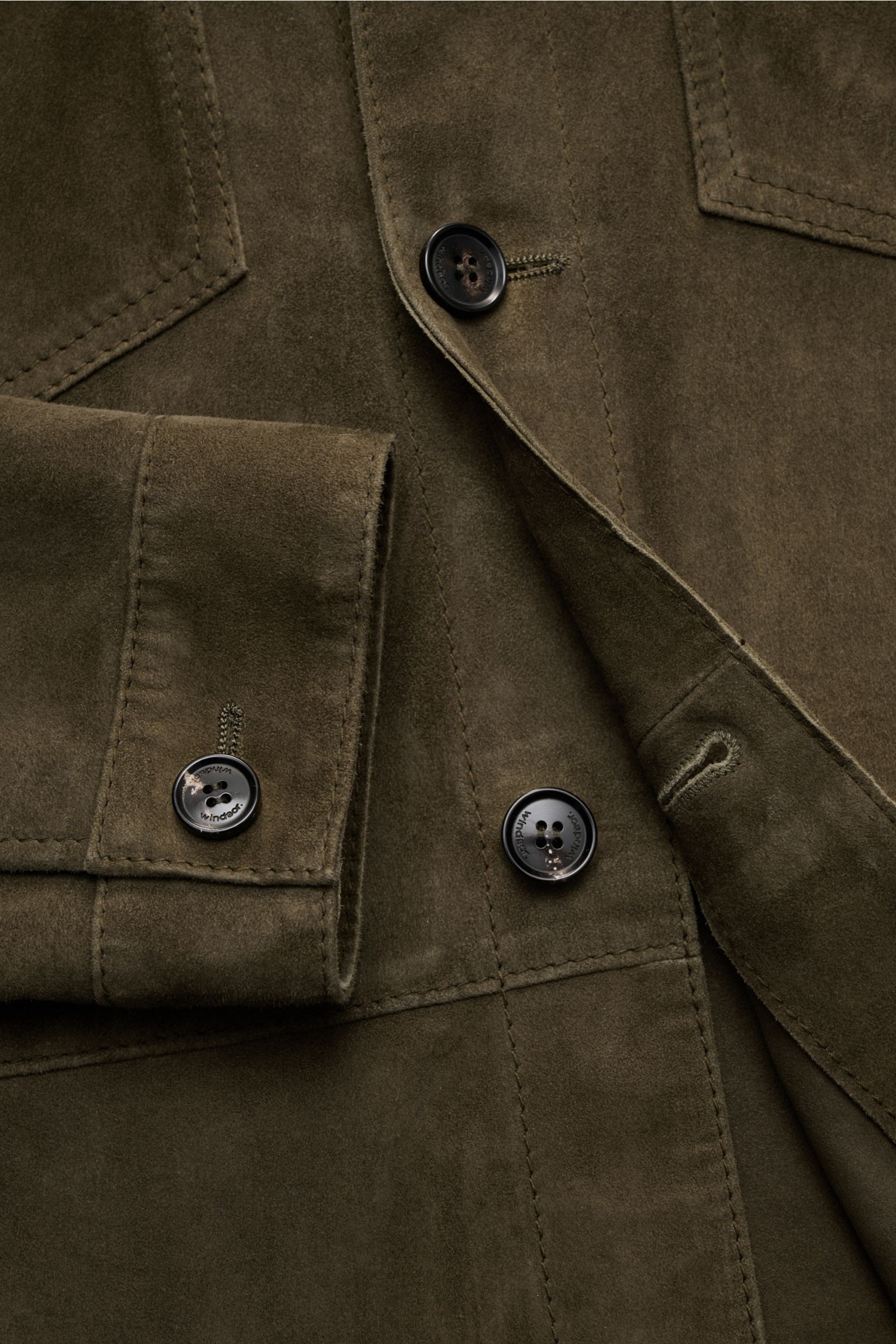 Nahaufnahme der Windsor Velourslederjacke 'Olfano' dark olive aus softem Ziegenvelours, Slim Fit, mit Manschetten, Brusttaschen und Fünf-Knopf-Leiste.