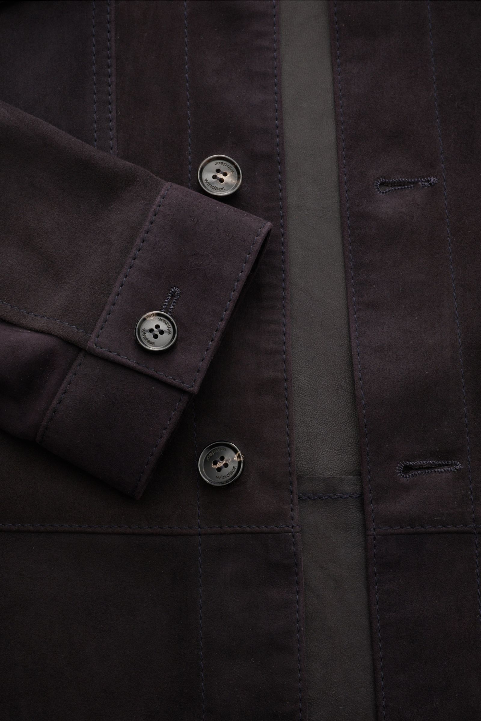 Close-up front view of Windsor Velourslederjacke 'Olfano' schwarz, showcasing soft black goat suede, slim fit, five-button placket, cuff with button, and patch chest pockets.

Die leichte Lederjacke 'Olfano' von WINDSOR aus feinem Ziegenvelours bestich