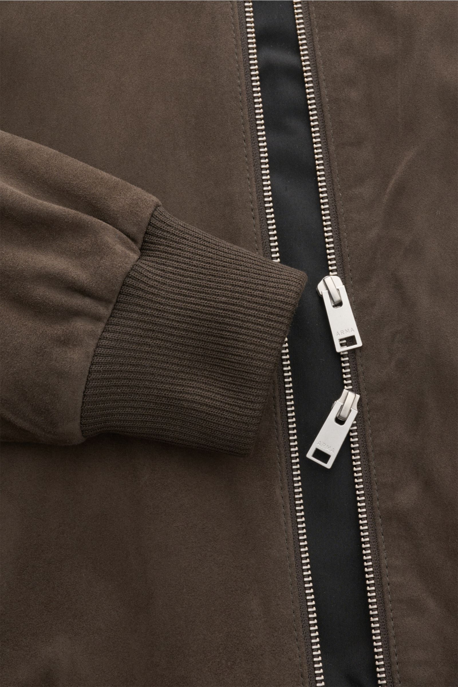 Nahaufnahme des Arma Veloursleder-Blouson 'Didier' dunkelbraun, seitliche Perspektive mit sichtbarem Zwei-Wege-Zipper und elastischem Rippbündchen.