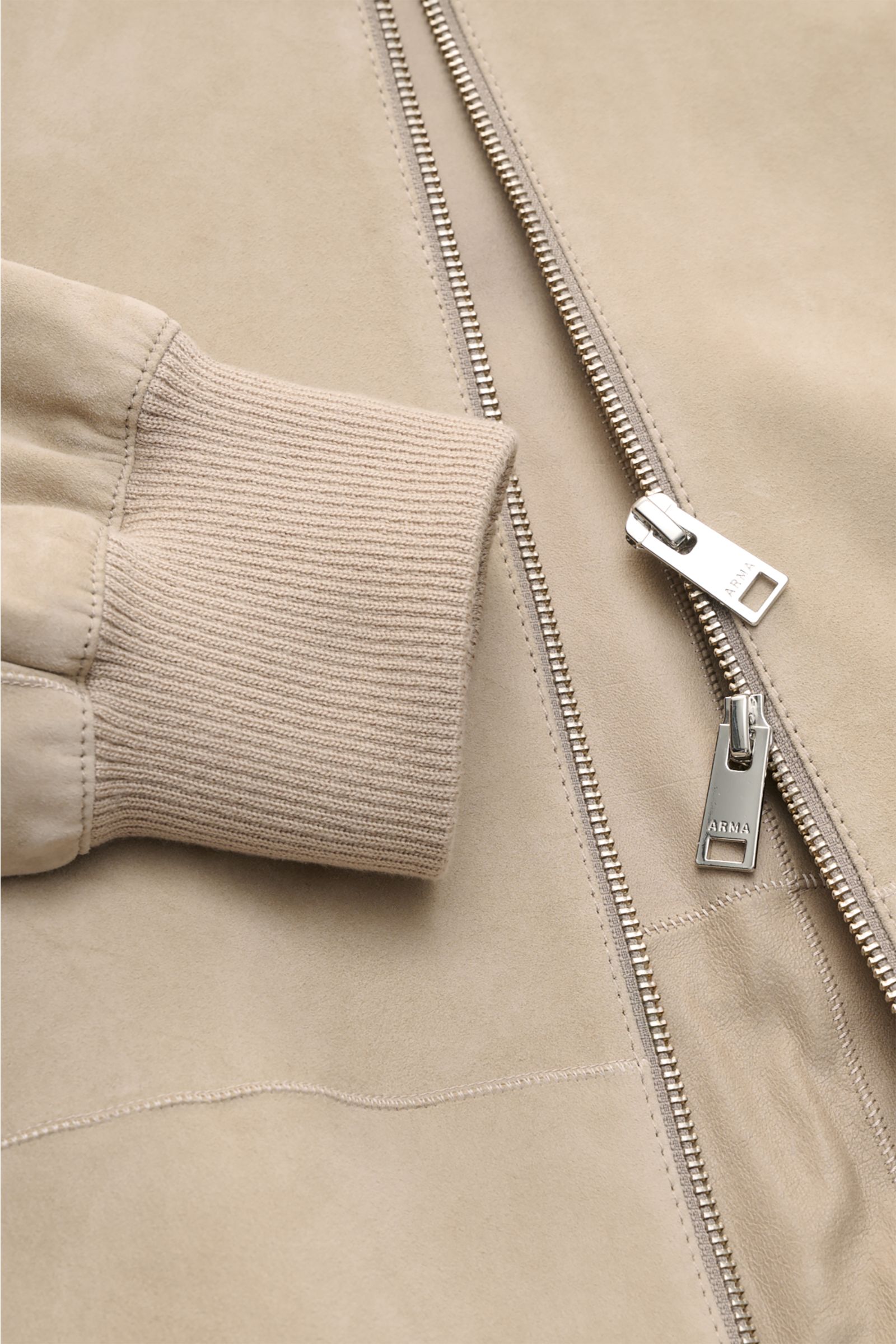 Nahaufnahme des Arma Veloursleder-Blouson 'Dion' beige mit elastischem Rippstrickbündchen, markantem Blousonkragen und robustem Zwei-Wege-Zipper.
