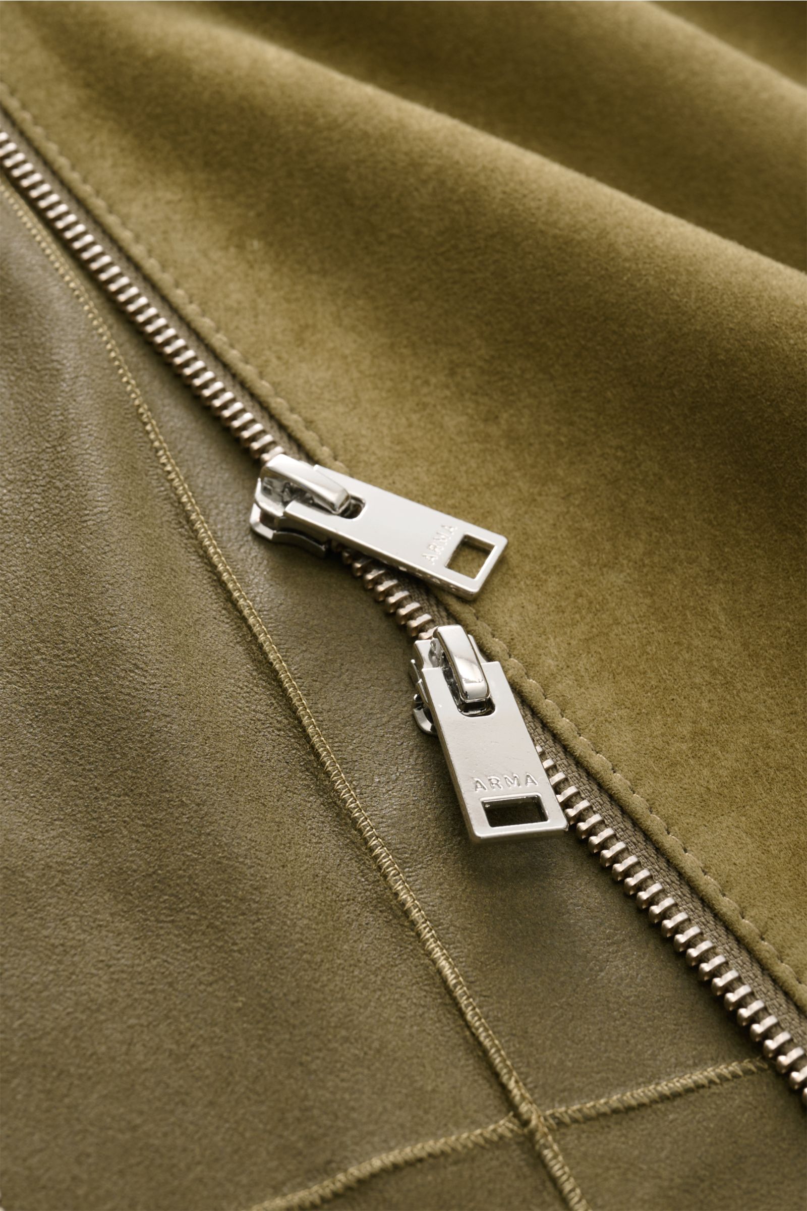 Close-up shot of the silver two-way zipper on the olive Arma Veloursleder-Blouson 'Dion', showing smooth goat suede leather texture.
