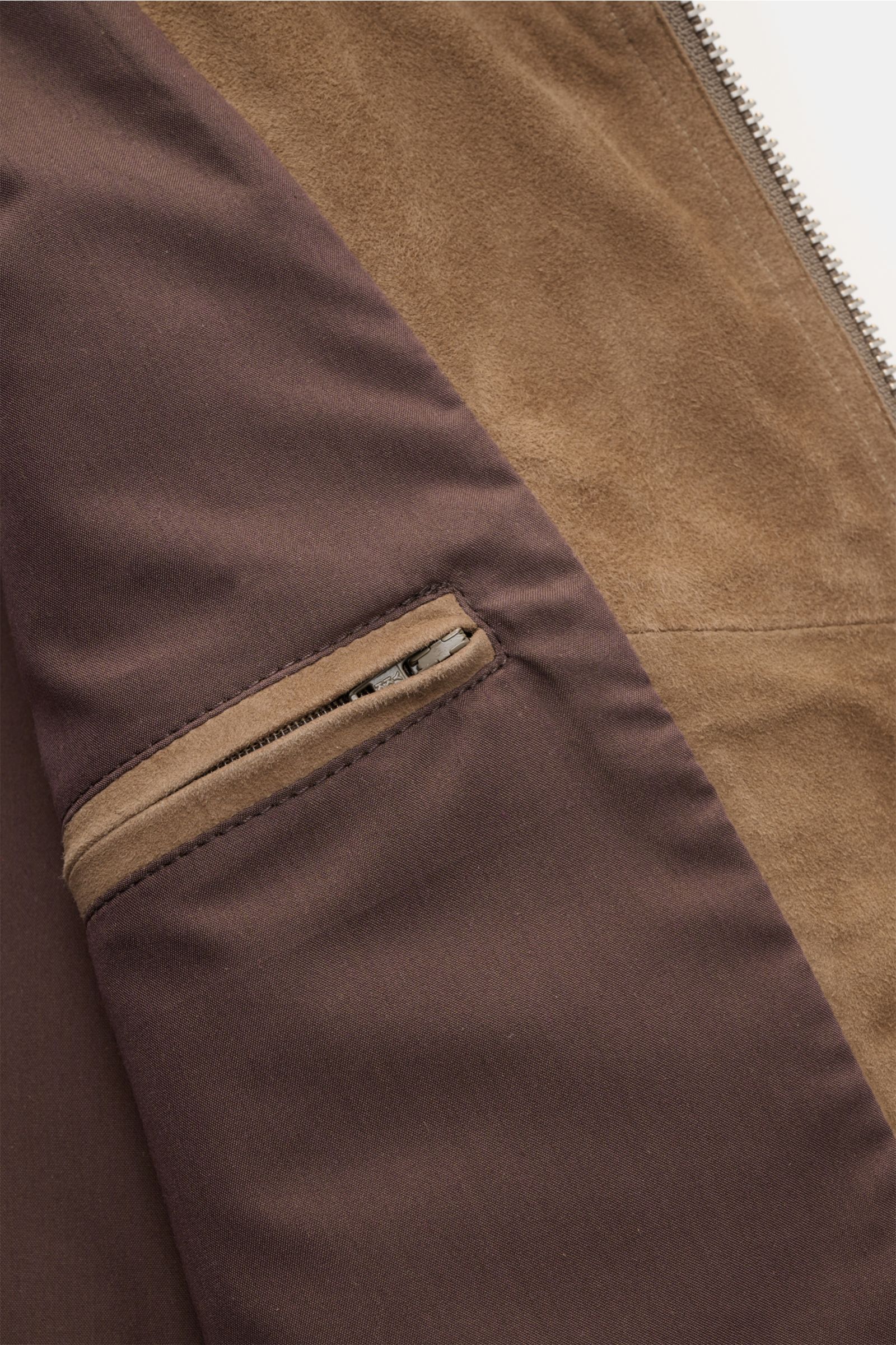 Nahaufnahme des Innenfutters der Arma Velourslederjacke 'Kale' taupe mit zwei Innentaschen, weichem Griff und Veloursleder.