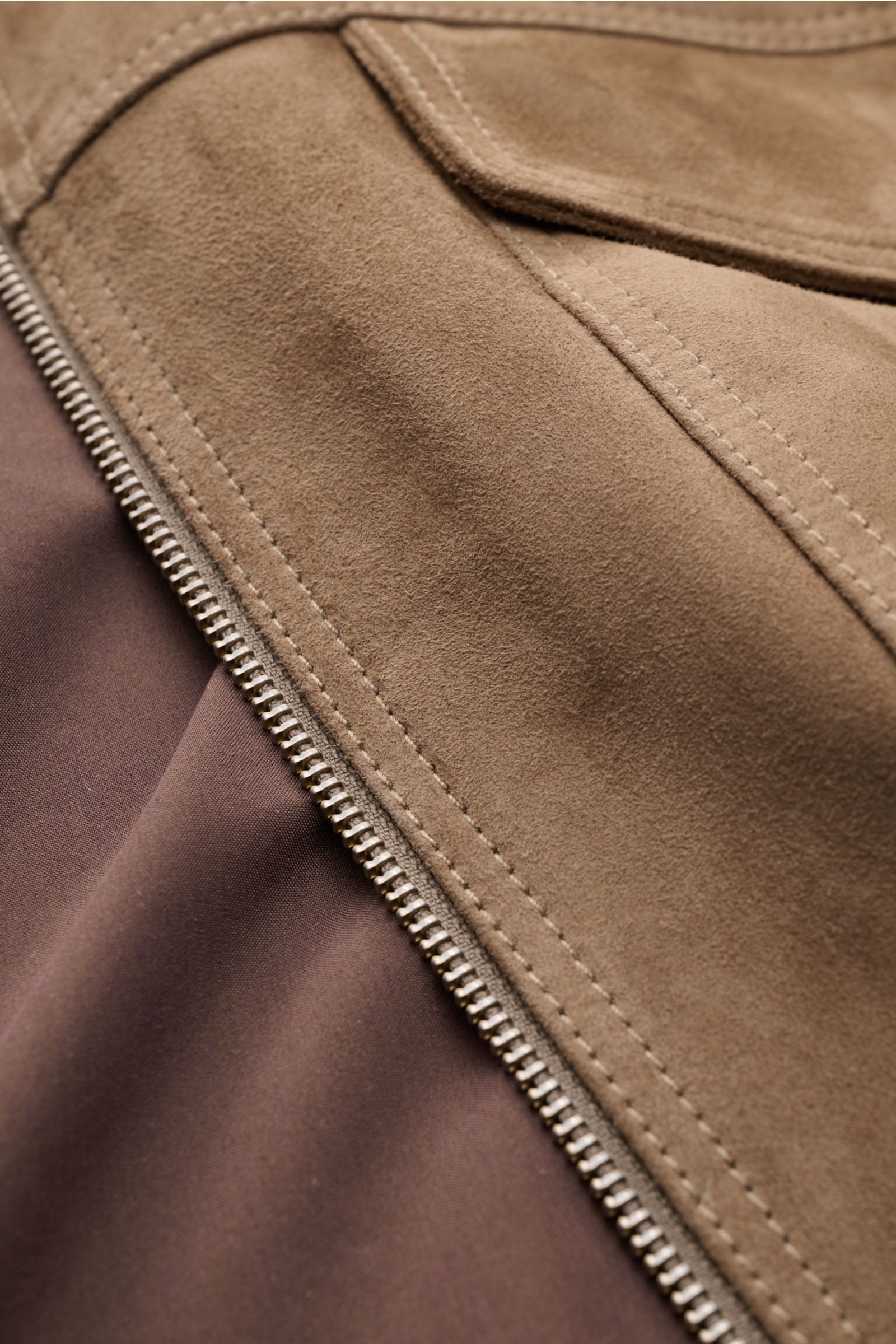 Nahaufnahme der Arma Velourslederjacke 'Kale' taupe von oben, zeigt weiches Veloursleder, zwei-Wege-Reißverschluss, Innenfutter.