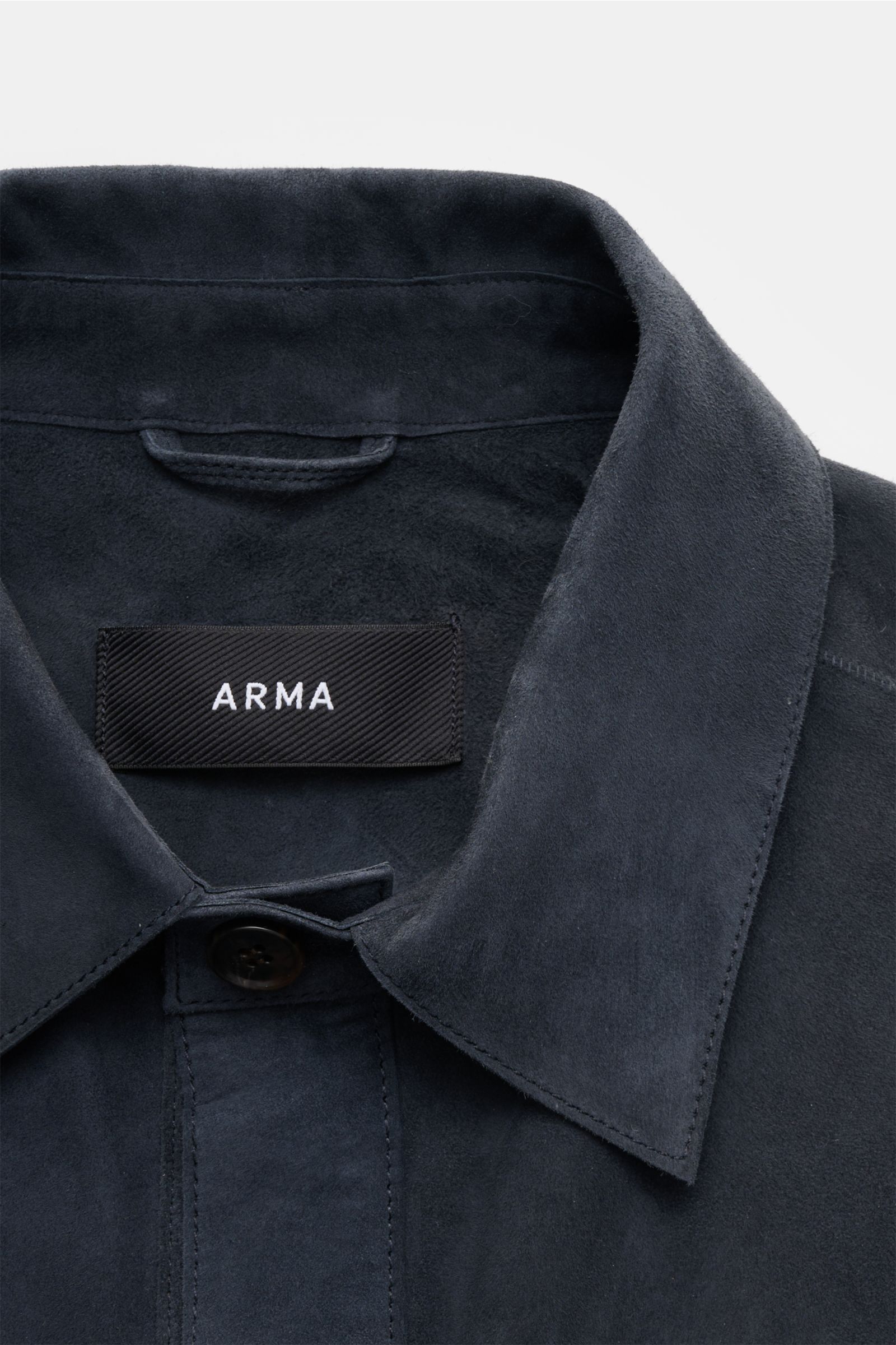 Close-up front view of the collar and top button of the Arma Velourslederjacke 'Dino' navy, crafted from soft velour leather with a slim fit and unconstructed design. Stylish transitional jacket featuring a soft touch, turn-down collar, six-button placket
